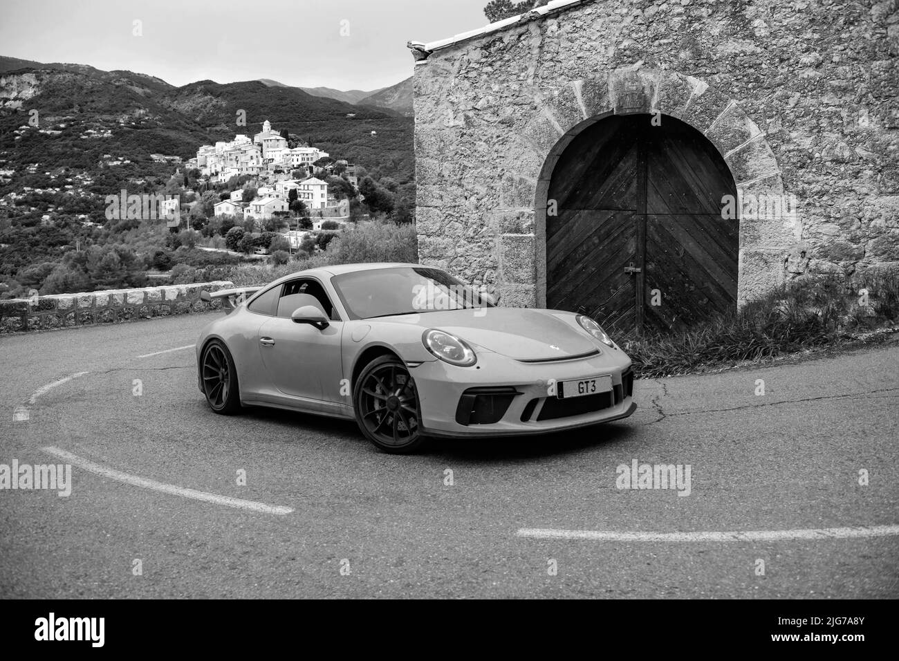 Re-enactment of classic black and white photo of Porsche 911 at historic track of Rally Monte Carlo 1965 with modern supercar sports car Porsche GT3 Stock Photo