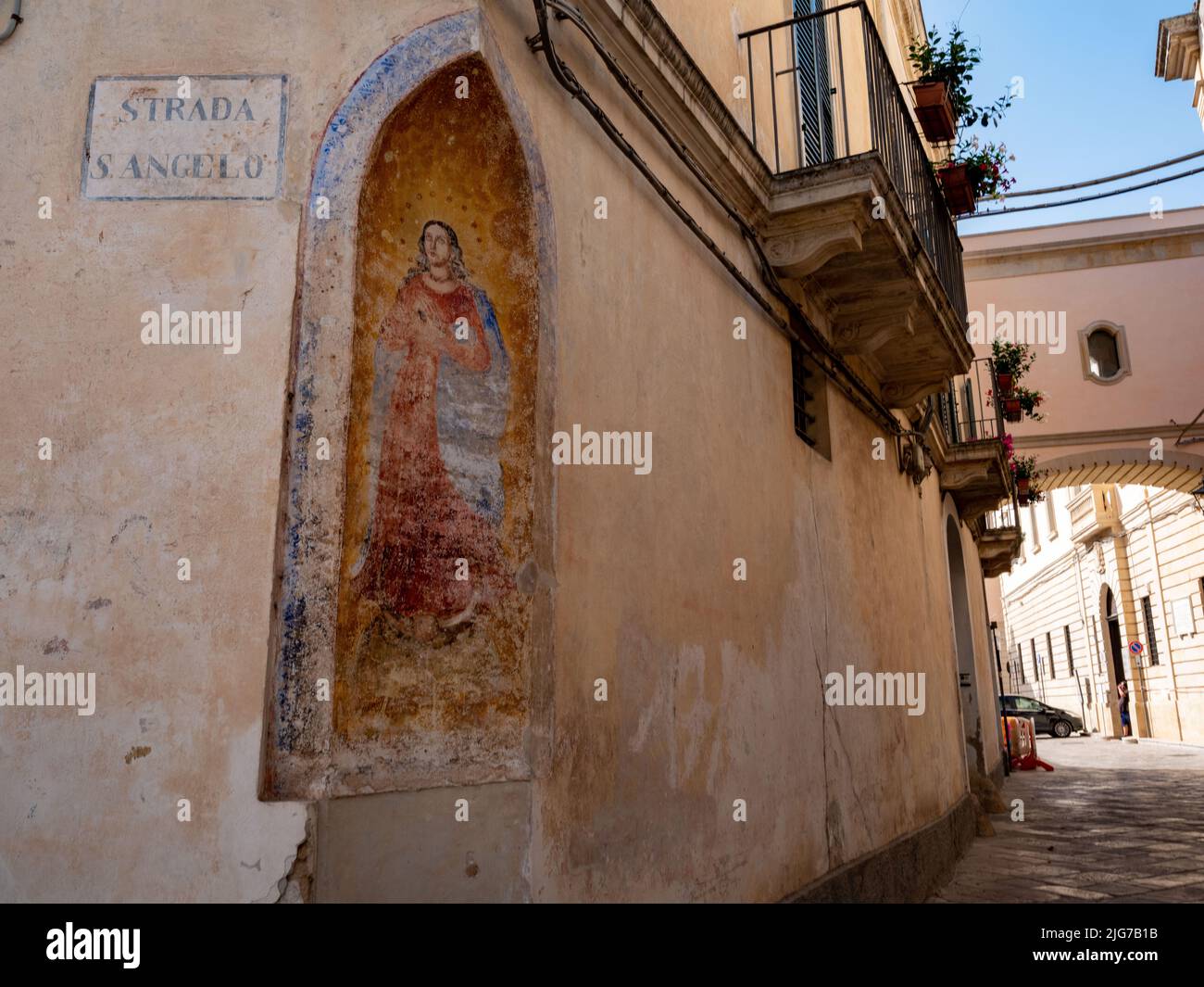 Street scene in the Old City of Nardo, Puglia with a cutout of the Virgin Mary at an intersection of two streets to give travelers a momentary pause Stock Photo