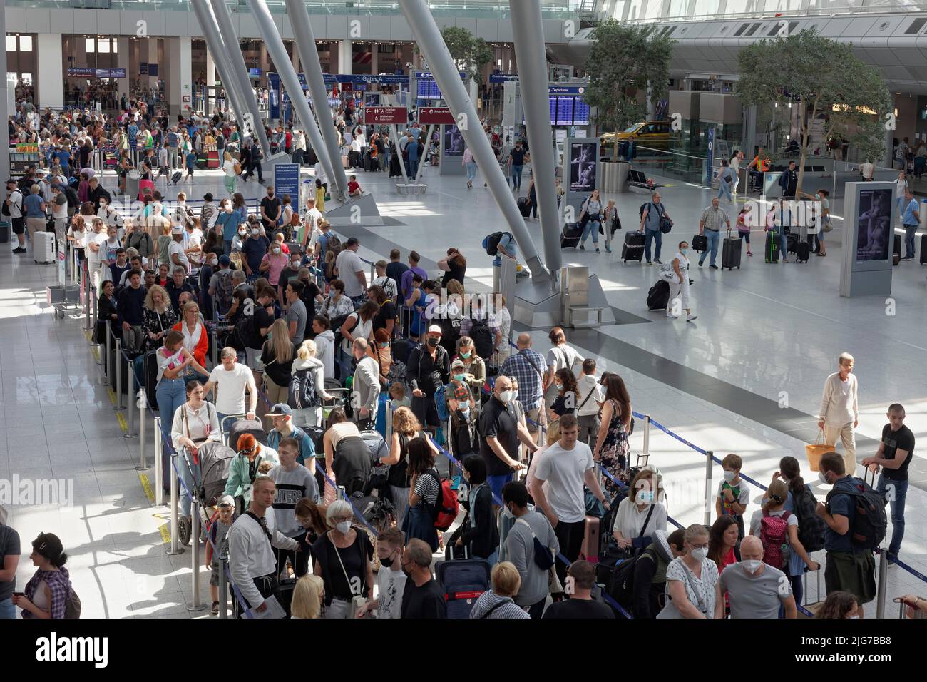 Passengers waiting for check-in in front of the check-in counter, queue during the summer holidays, Duesseldorf Airport, North Rhine-Westphalia Stock Photo