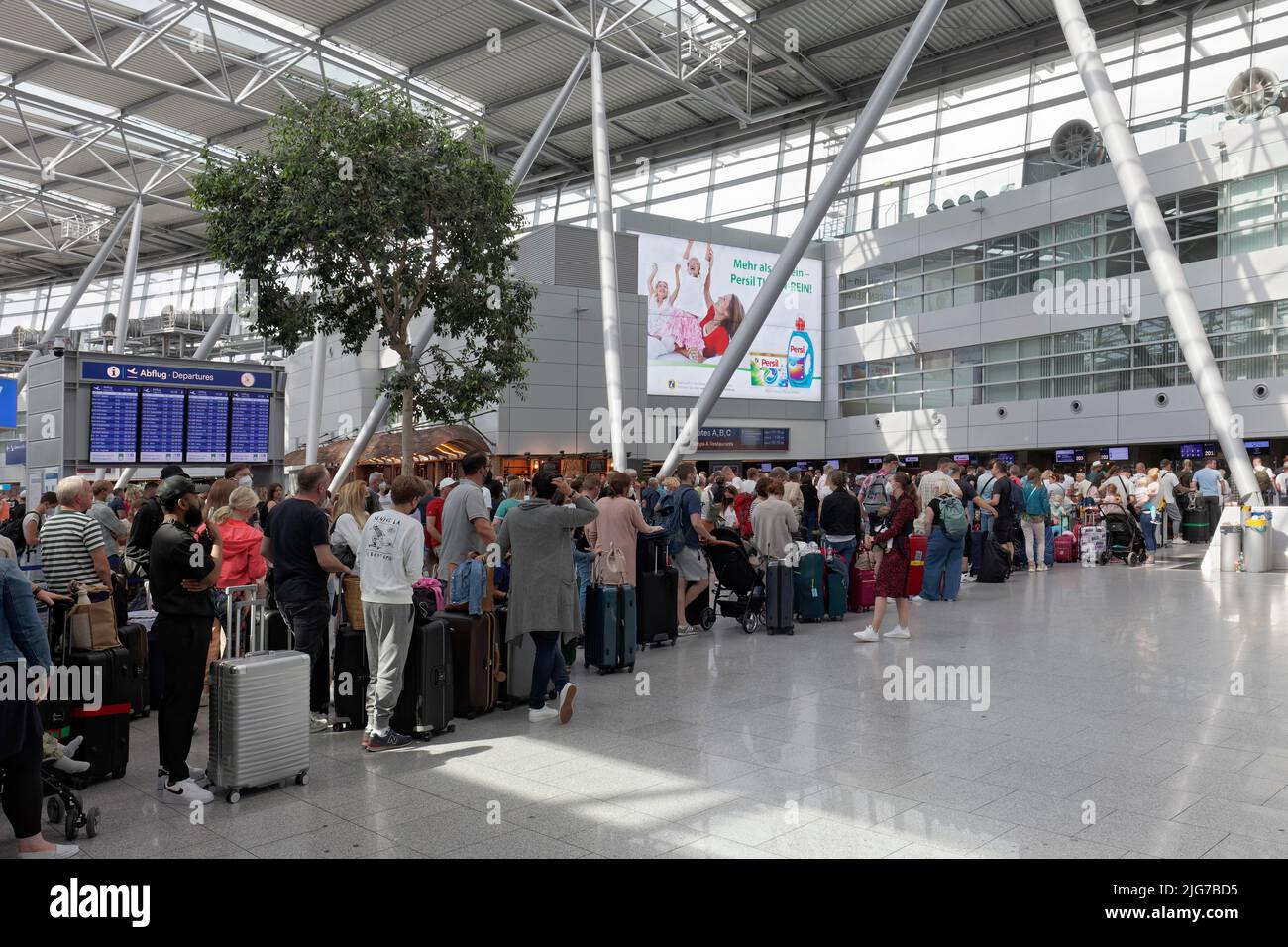 Passengers waiting for check-in in front of the check-in counter, queue during the summer holidays, Duesseldorf Airport, North Rhine-Westphalia Stock Photo