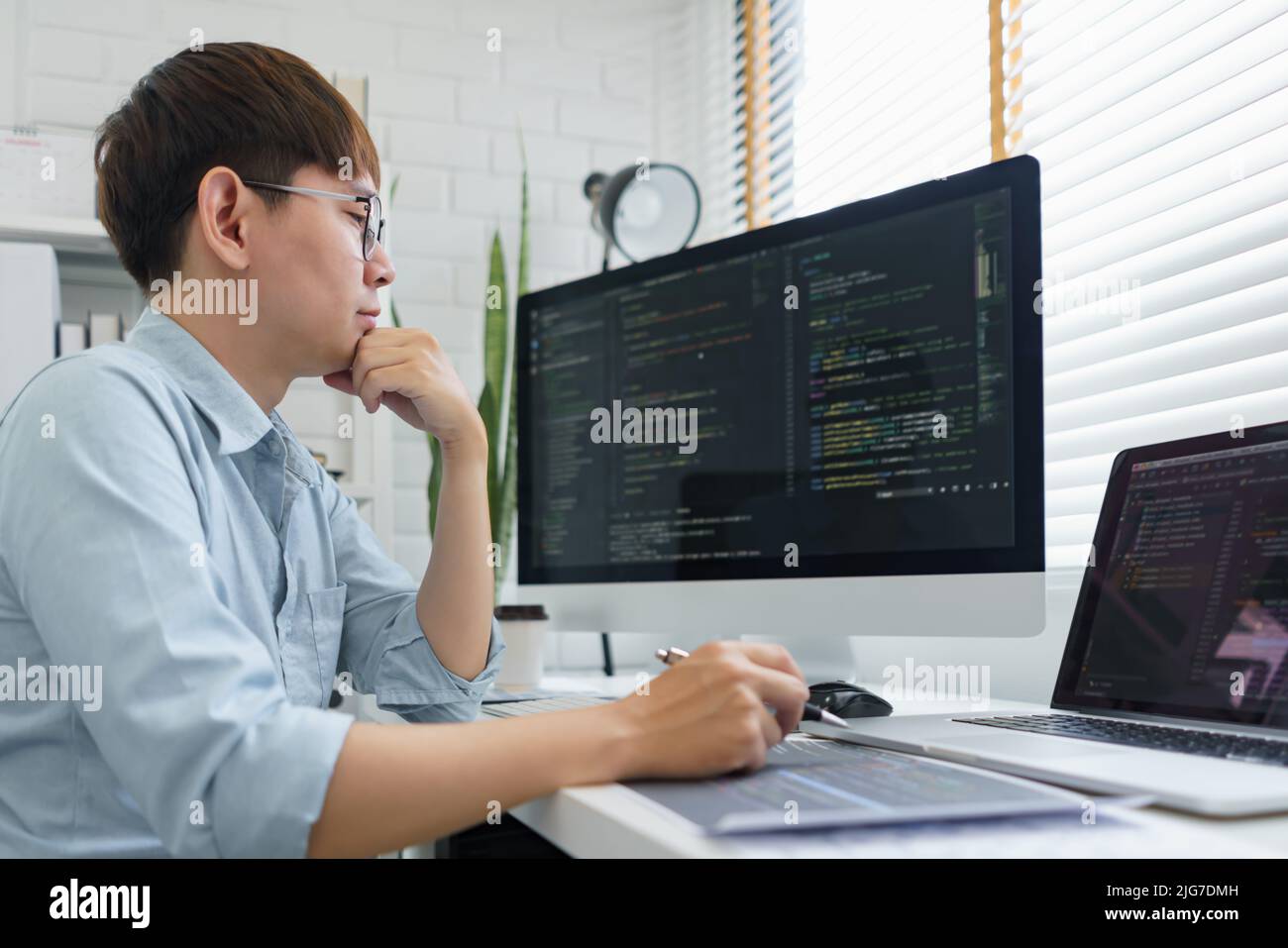 Software development concept, Male programmer read data code to thinking about developing website. Stock Photo
