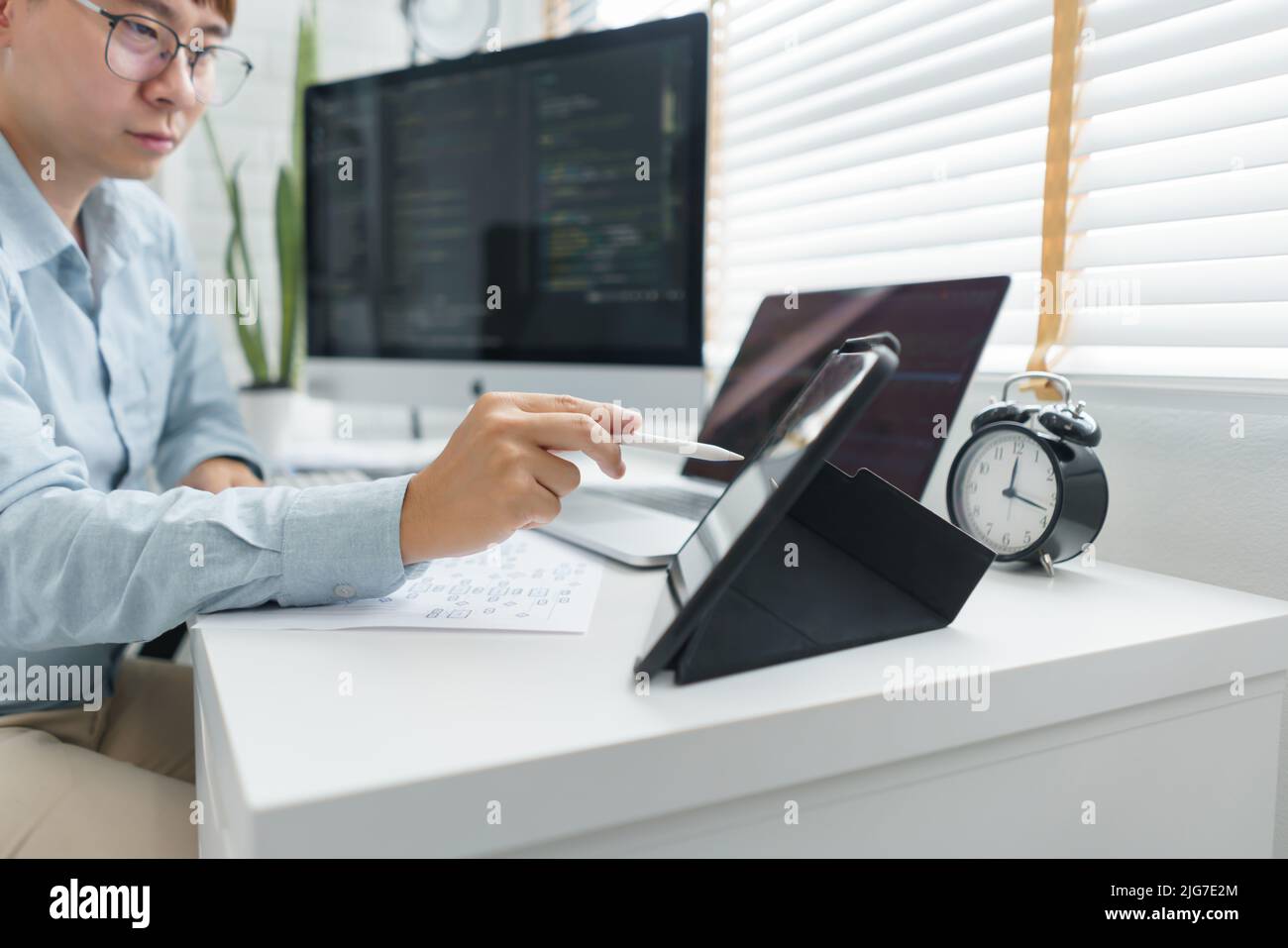 Software development concept, Male programmer point data on tablet to checking website programming. Stock Photo