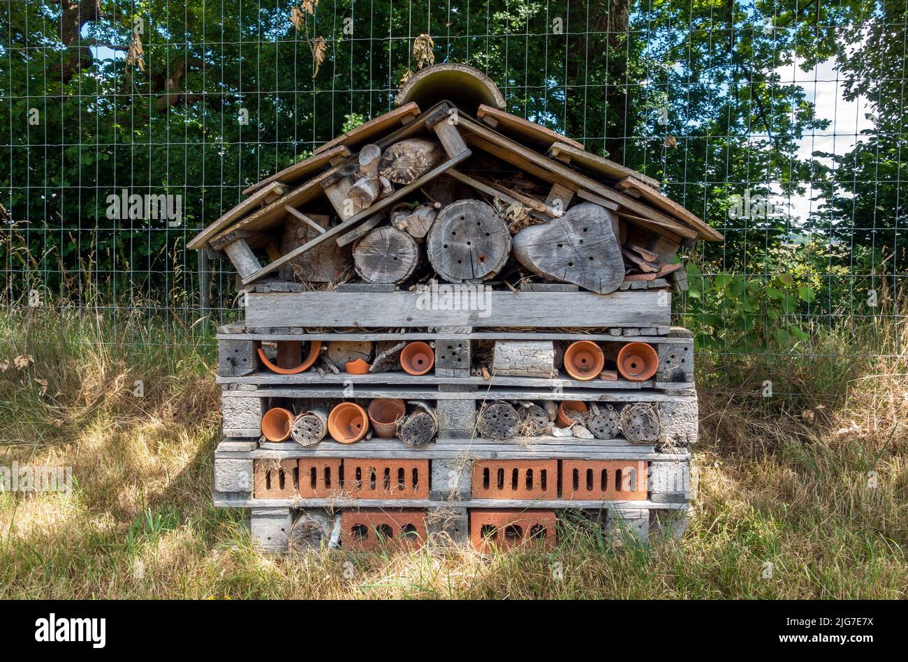 Large bug hotel made from brick and wood providing a safe hideaway for wildlife Stock Photo