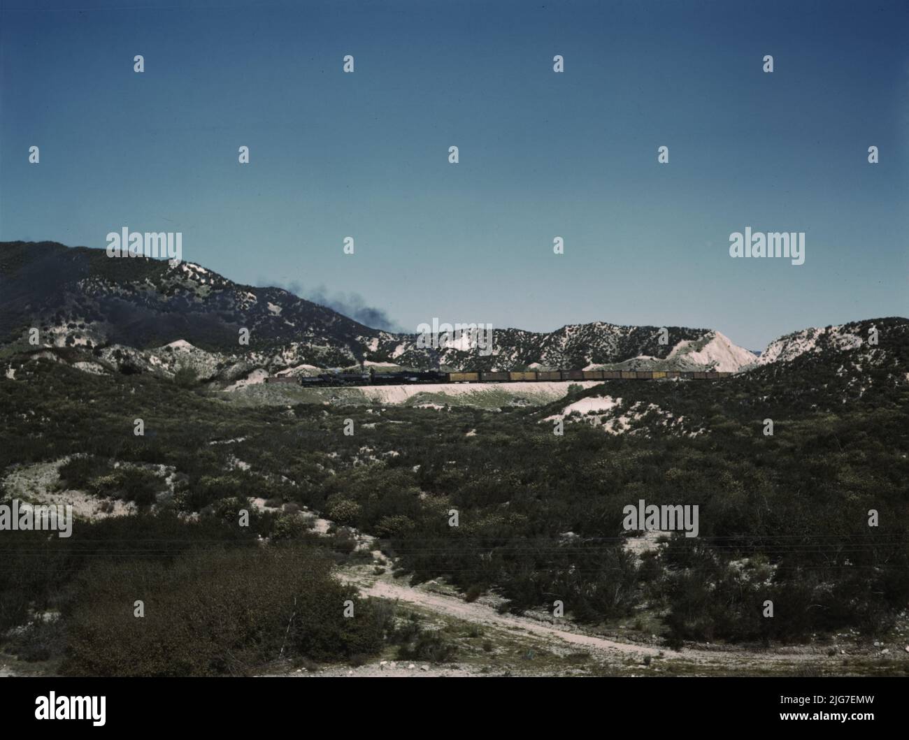 Freight train with two helper engines climbing the steep grade of Cajon