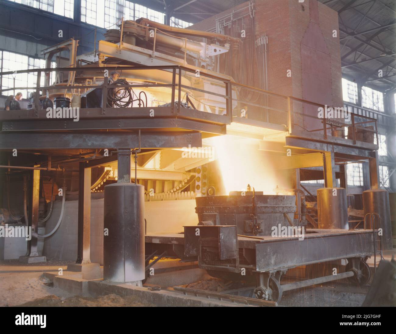 White-hot steel pours like water from a 35-ton electric furnace, Allegheny Ludlum Steel[e] Corp., Brackenridge, Pa. The finest quality steels and alloys are produced in these furnaces, which allow much greater control of temperature than other conversion furnaces. The proportion of electric furnace steel is rising steadily, even though this process is the most expensive. &quot;The furnace is tilted for the pouring.&quot; The flying sparks indicate the fluidity of the steel. Stock Photo