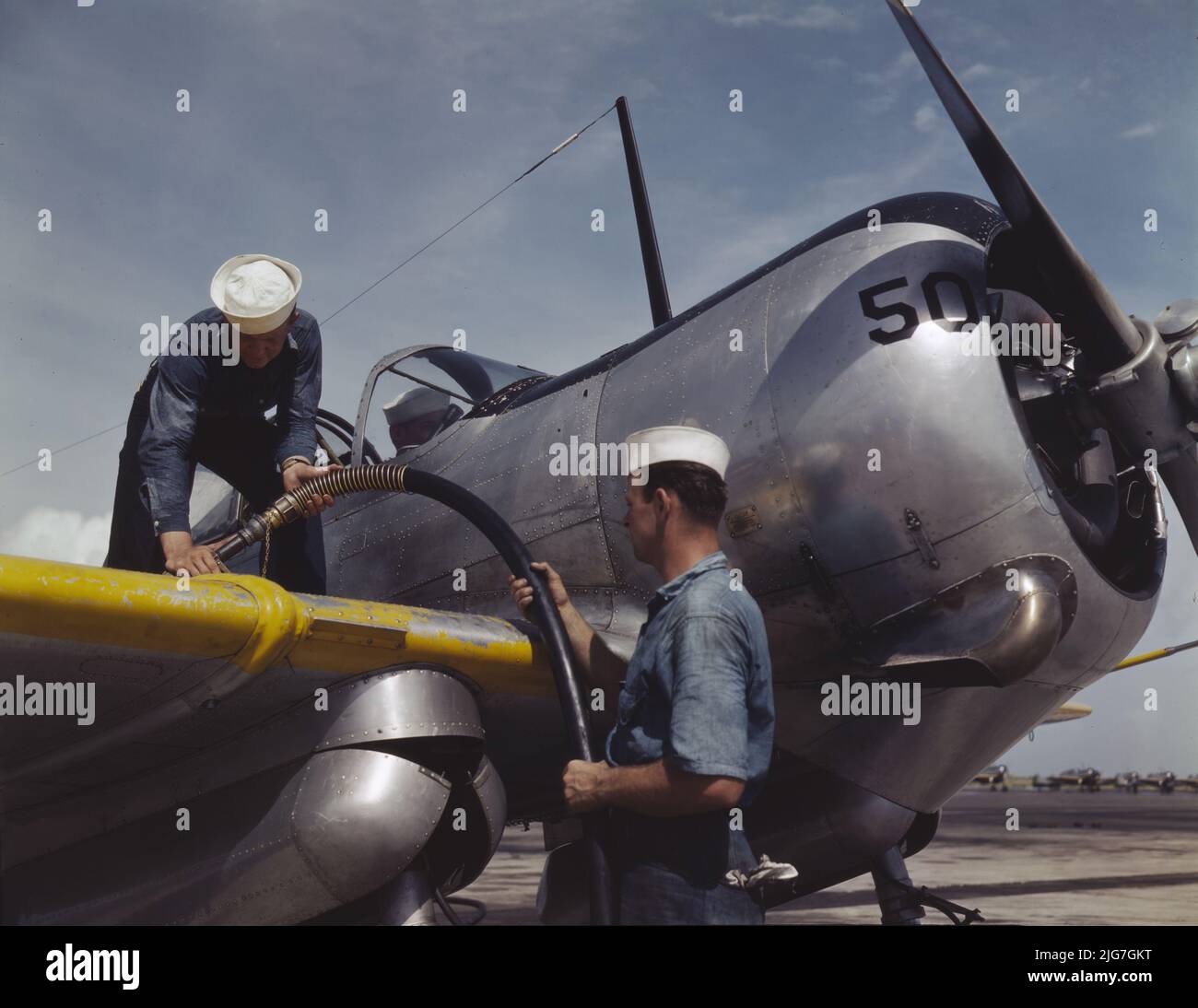 Feeding an SNC advanced training plane its essential supply of gasoline is done by sailor mechanics at the Naval Air Base, Corpus Christi, Texas. Standing on the wing is Floyd Helphrey who came from Iowa to join the Navy early in the year. At right is W. Gardner of Illinois who used to be a crane operator. Stock Photo