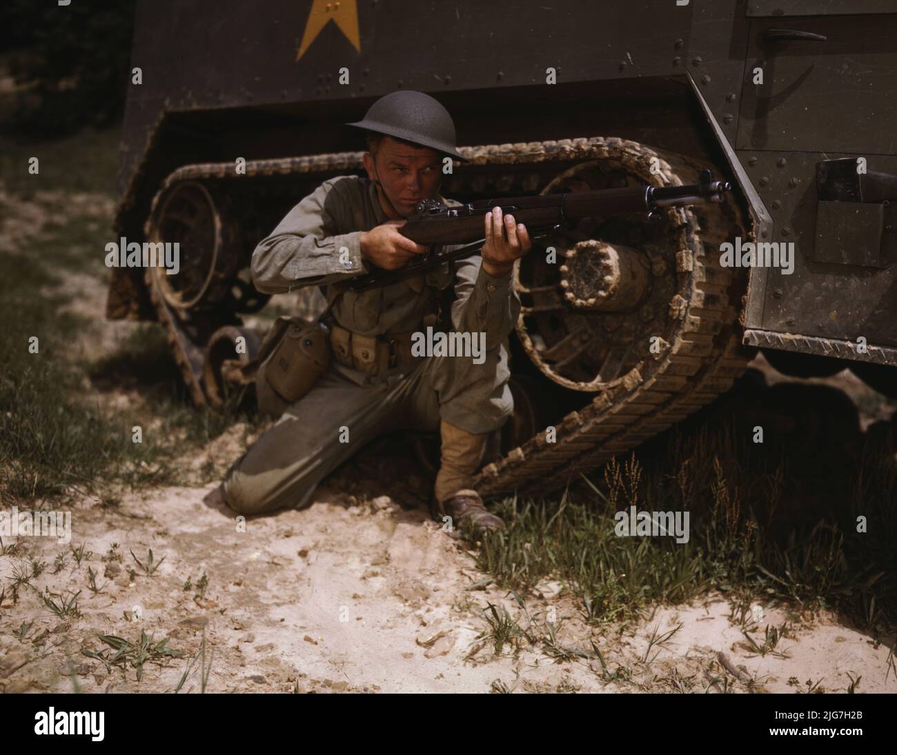 A young soldier of the armored forces holds and sights his Garand rifle like an old timer, Fort Knox, Ky. He likes the piece for its fine firing qualities and its rugged, dependable mechanism. Infantryman with halftrack. Stock Photo