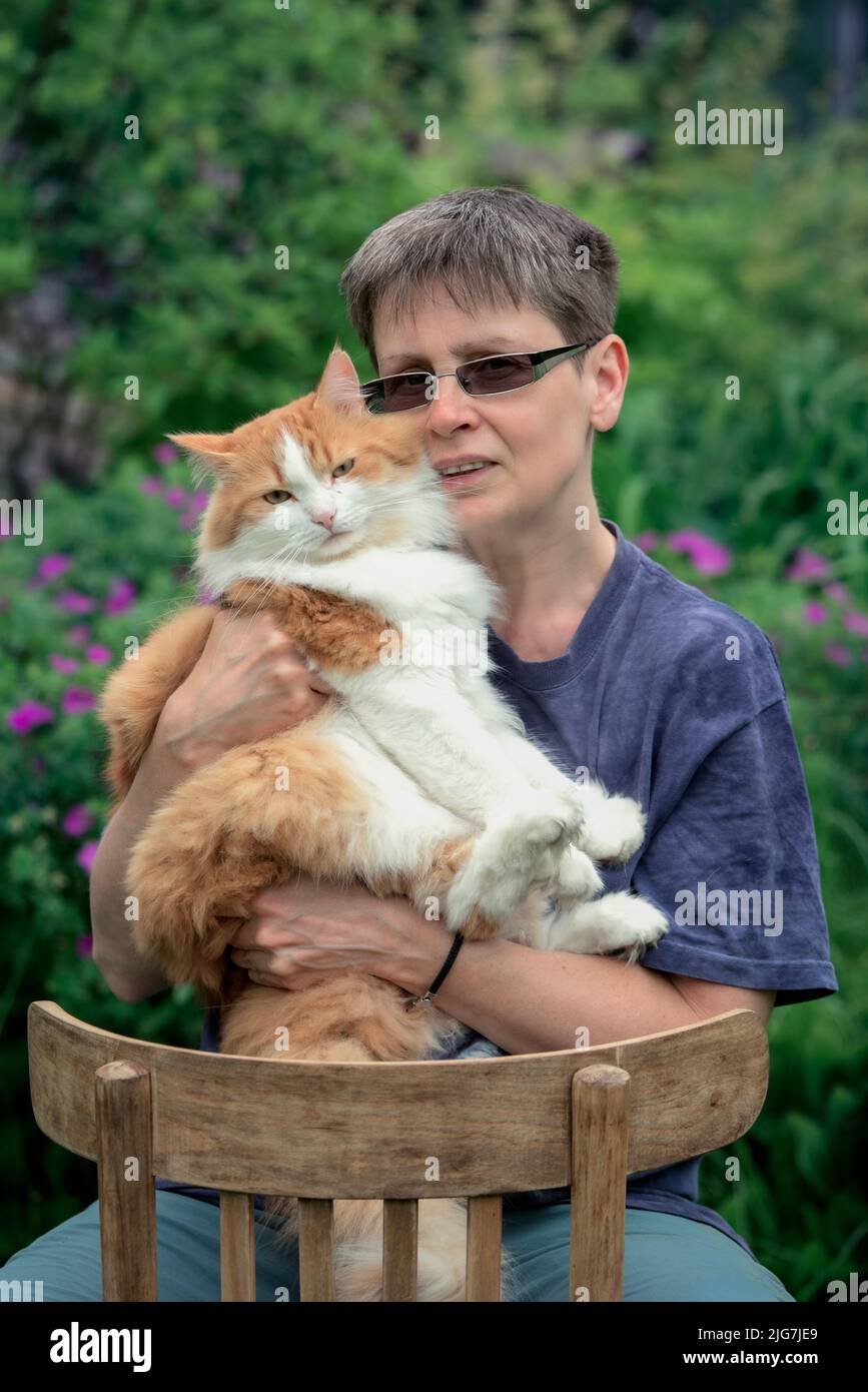 Woman with her cat sitting outdoor Stock Photo