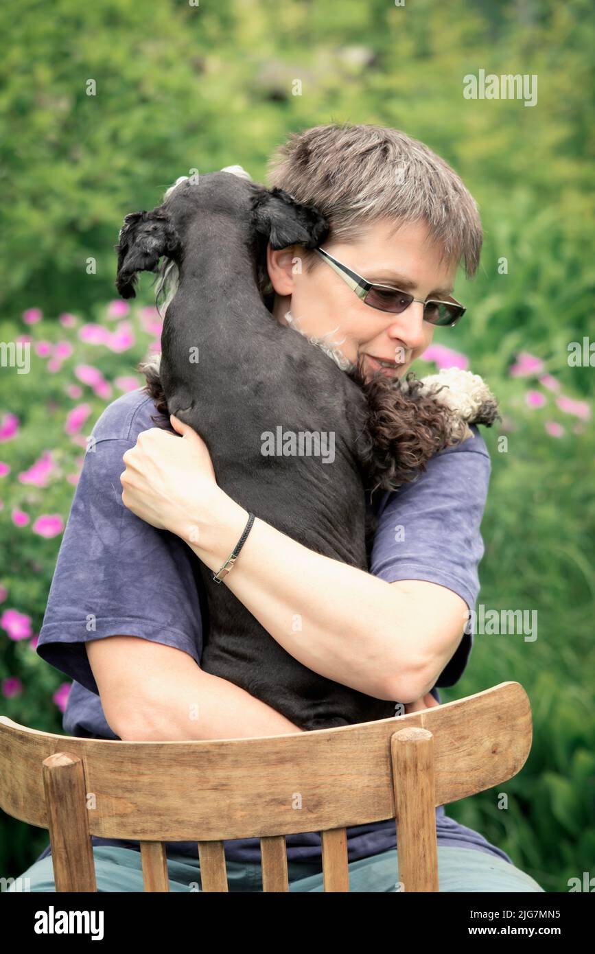 Portrait of a woman hugging a dog Stock Photo