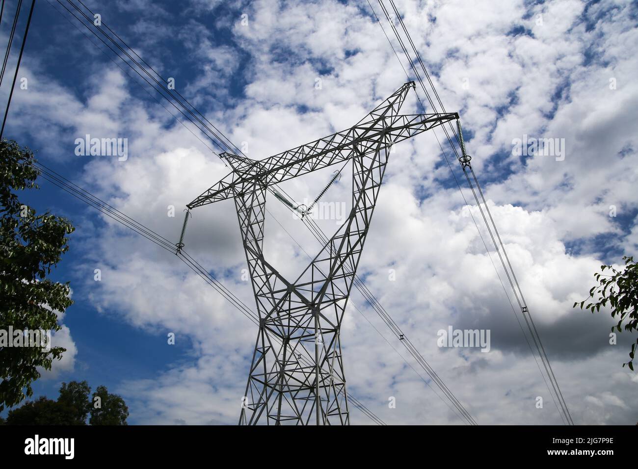 High voltage electric pole against blue sky background Stock Photo - Alamy