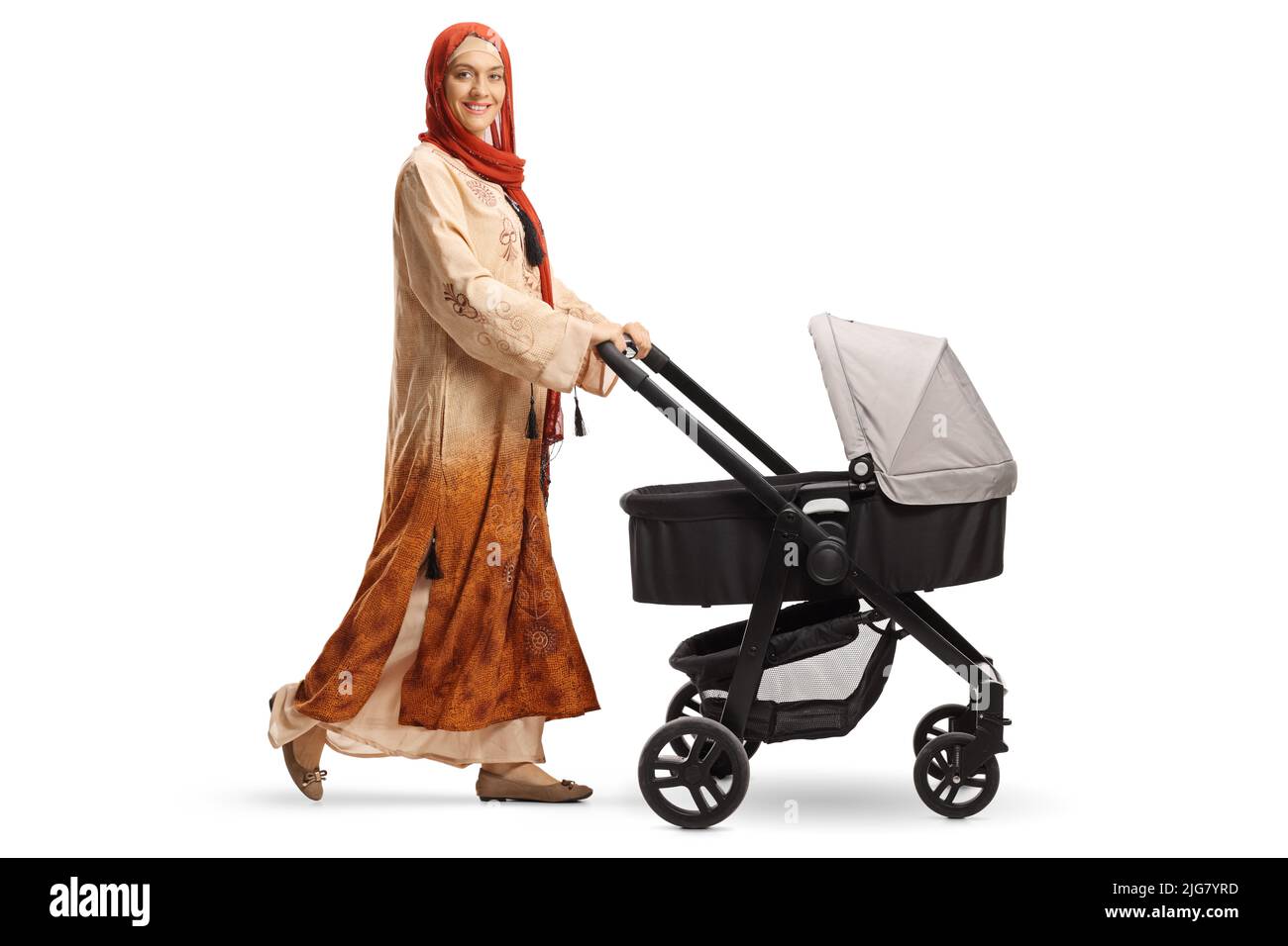 Full length shot of a young mother in ethnic clothes with hijab pushing a baby stroller isolated on white background Stock Photo