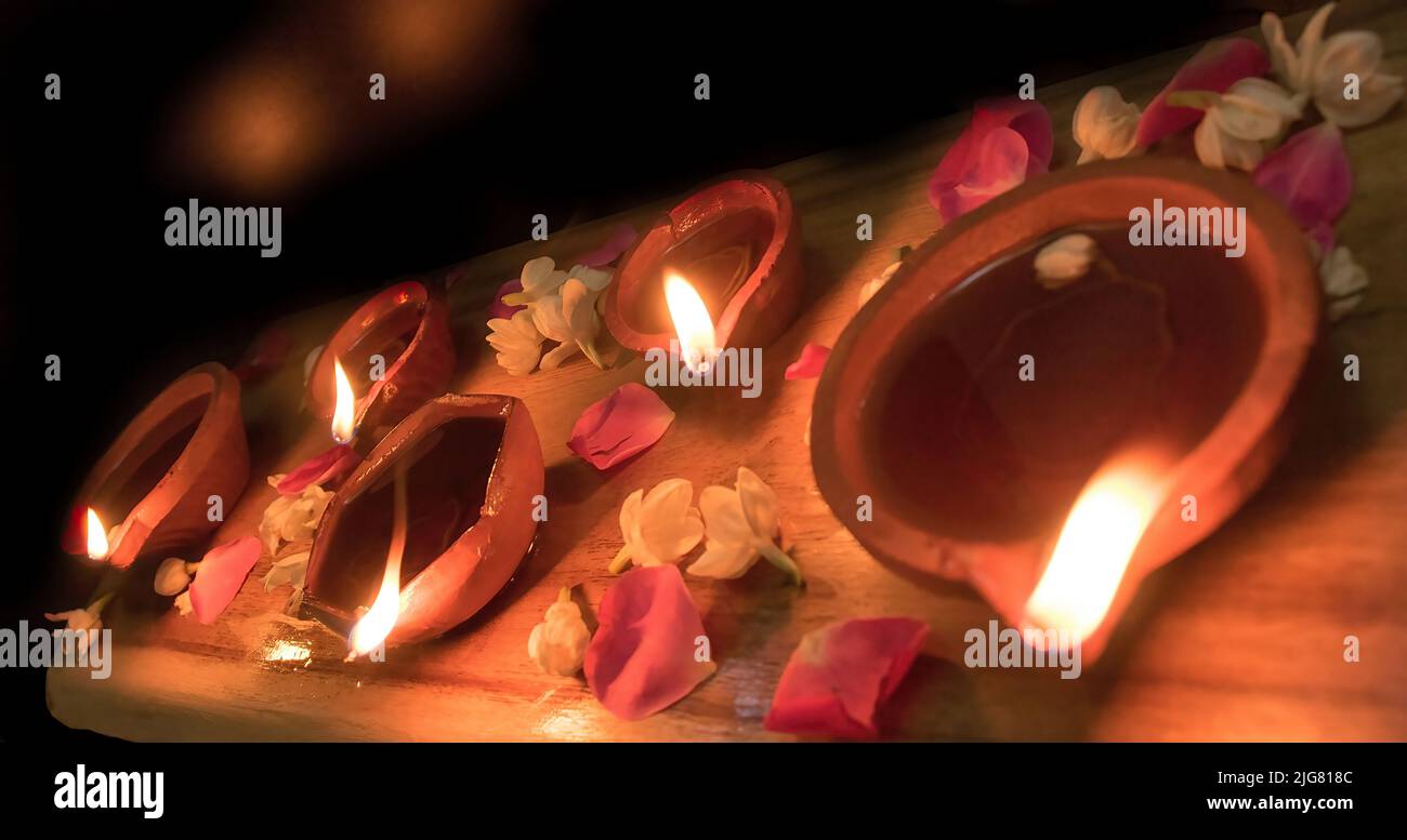 Diya lamp and oil lamp with fire and candles and color on dark