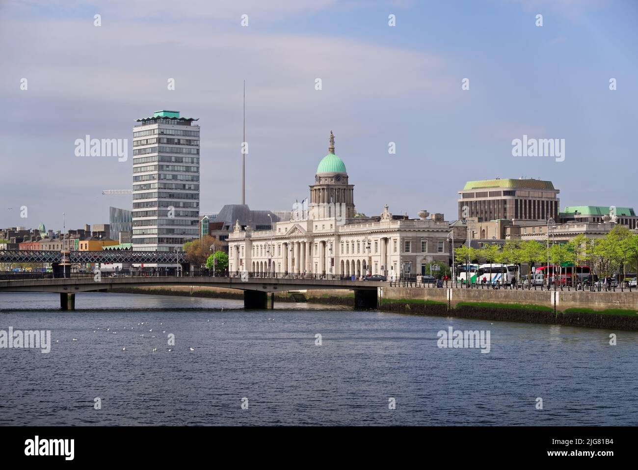 City landscape with landmarks of Dublin visible on the horizon. The Custom House, the Spire and the Liberty Hall by the River Liffey on sunny day. Stock Photo