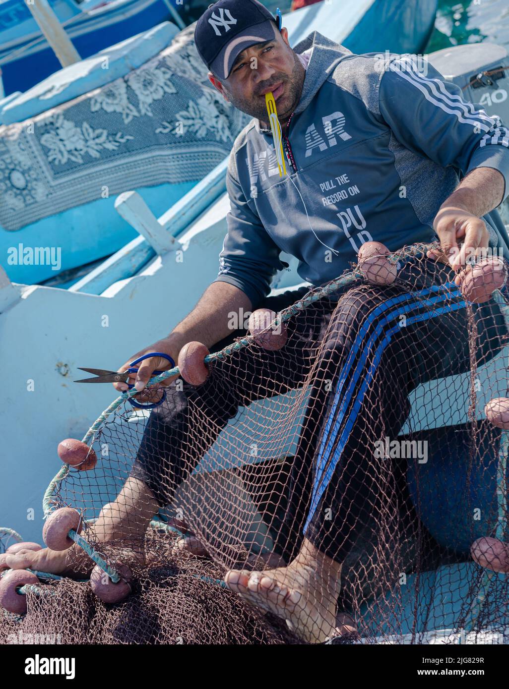 Hurghada, Egypt February 21, 2022 Fisherman sewing fishing nets in