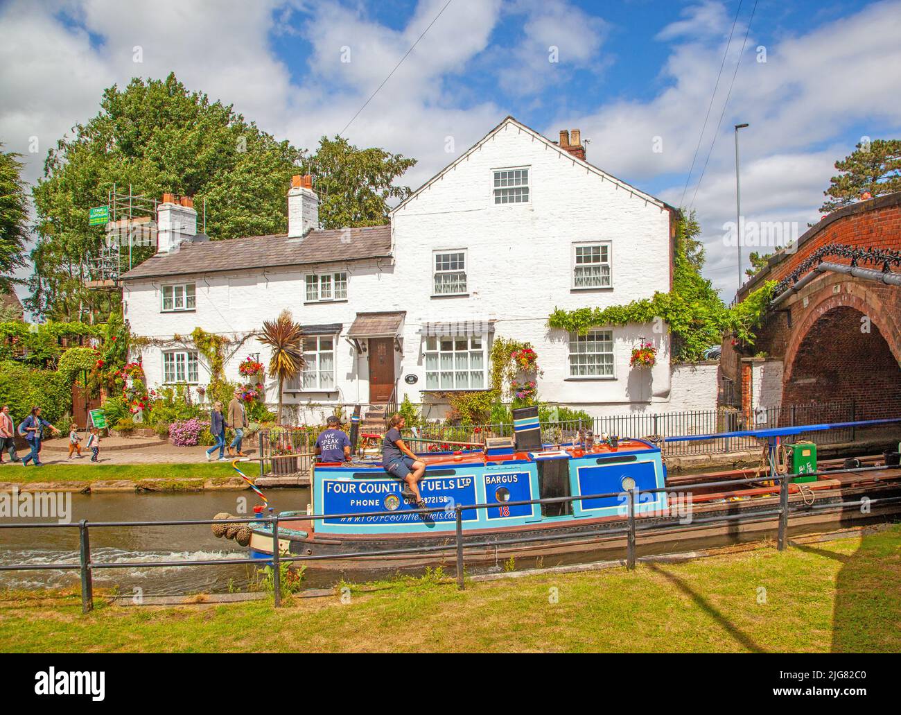 Canal narrowboat passing through the Cheshire village of Lymm on the Bridgewater canal Stock Photo