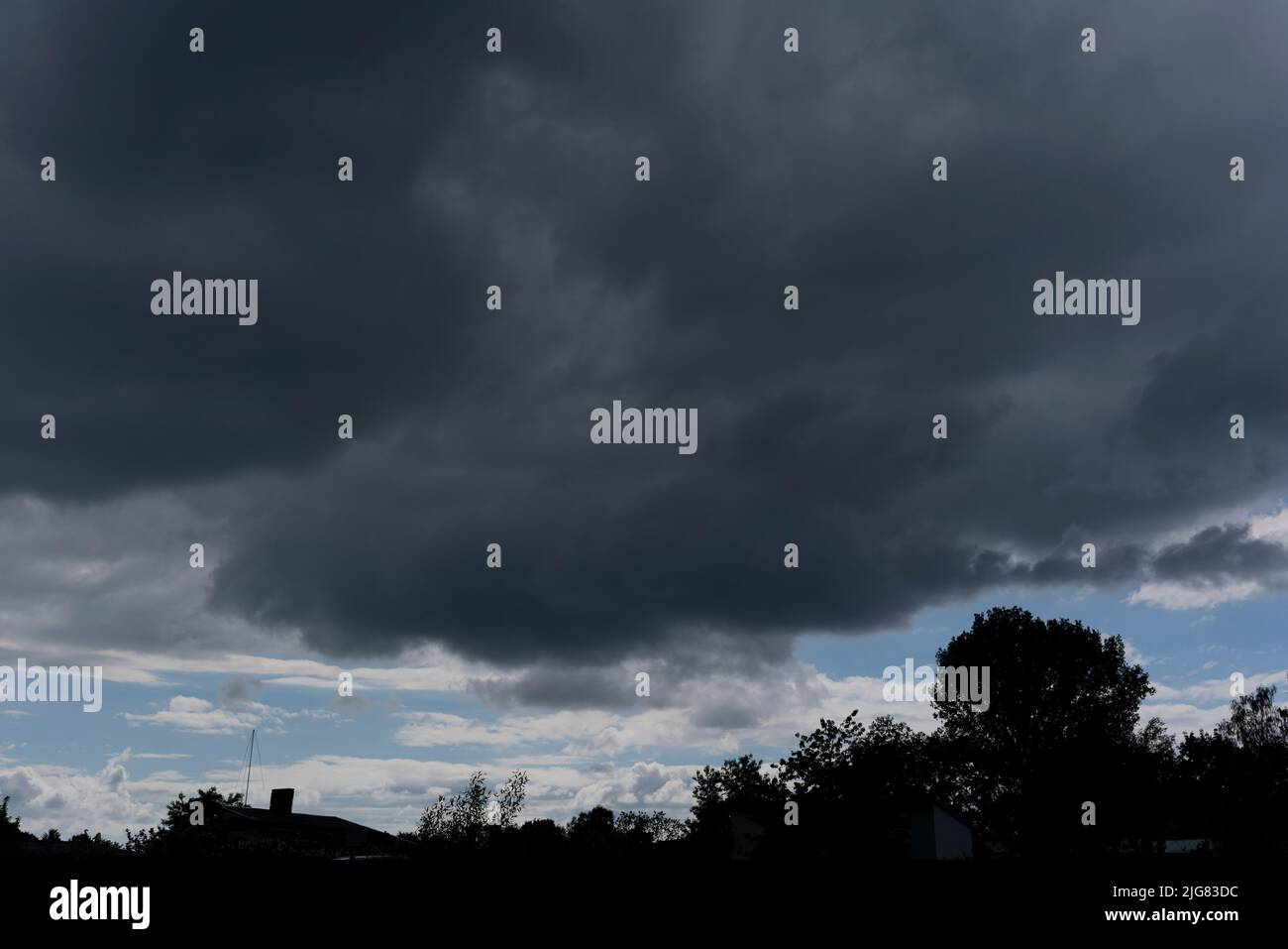Low-hanging large grey rain cloud over Germany in spring Stock Photo