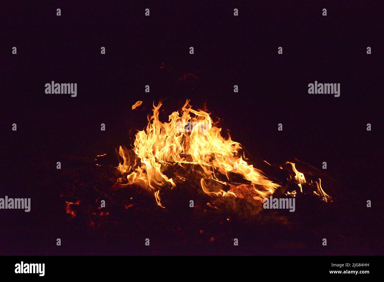 A campfire with flames in the darkness Stock Photo - Alamy