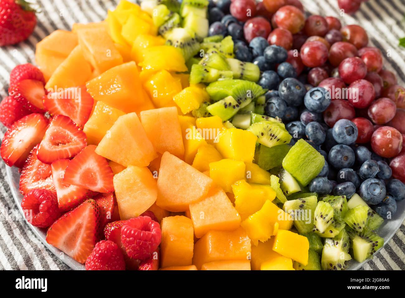 Raw Organic Rainbow Fruit Salad with Berries Melons and Grapes Stock Photo
