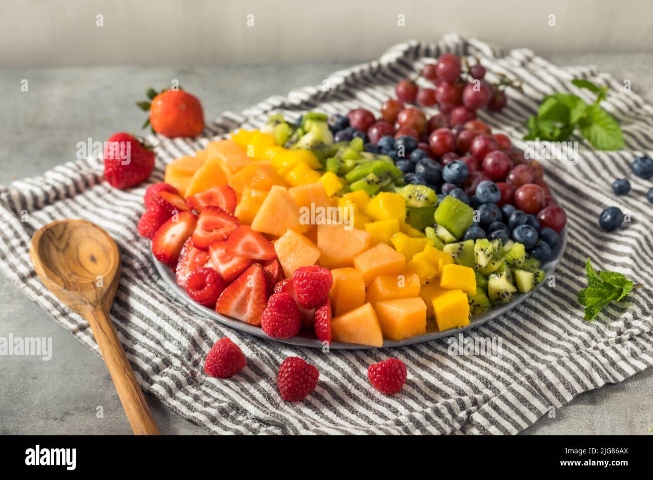 Raw Organic Rainbow Fruit Salad with Berries Melons and Grapes Stock Photo