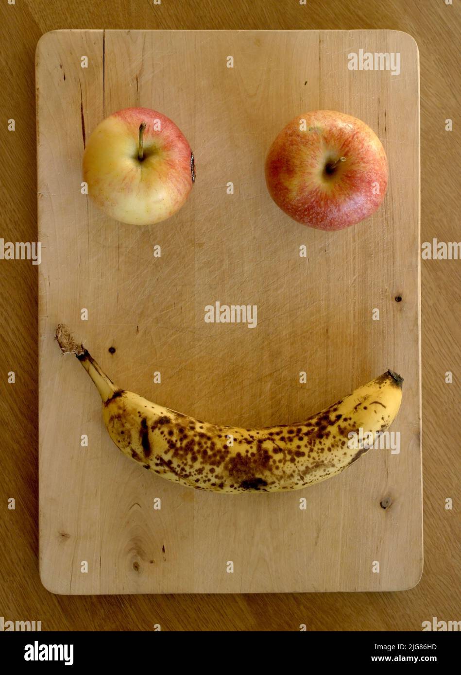 Two apples and a banana forming a face. Stock Photo