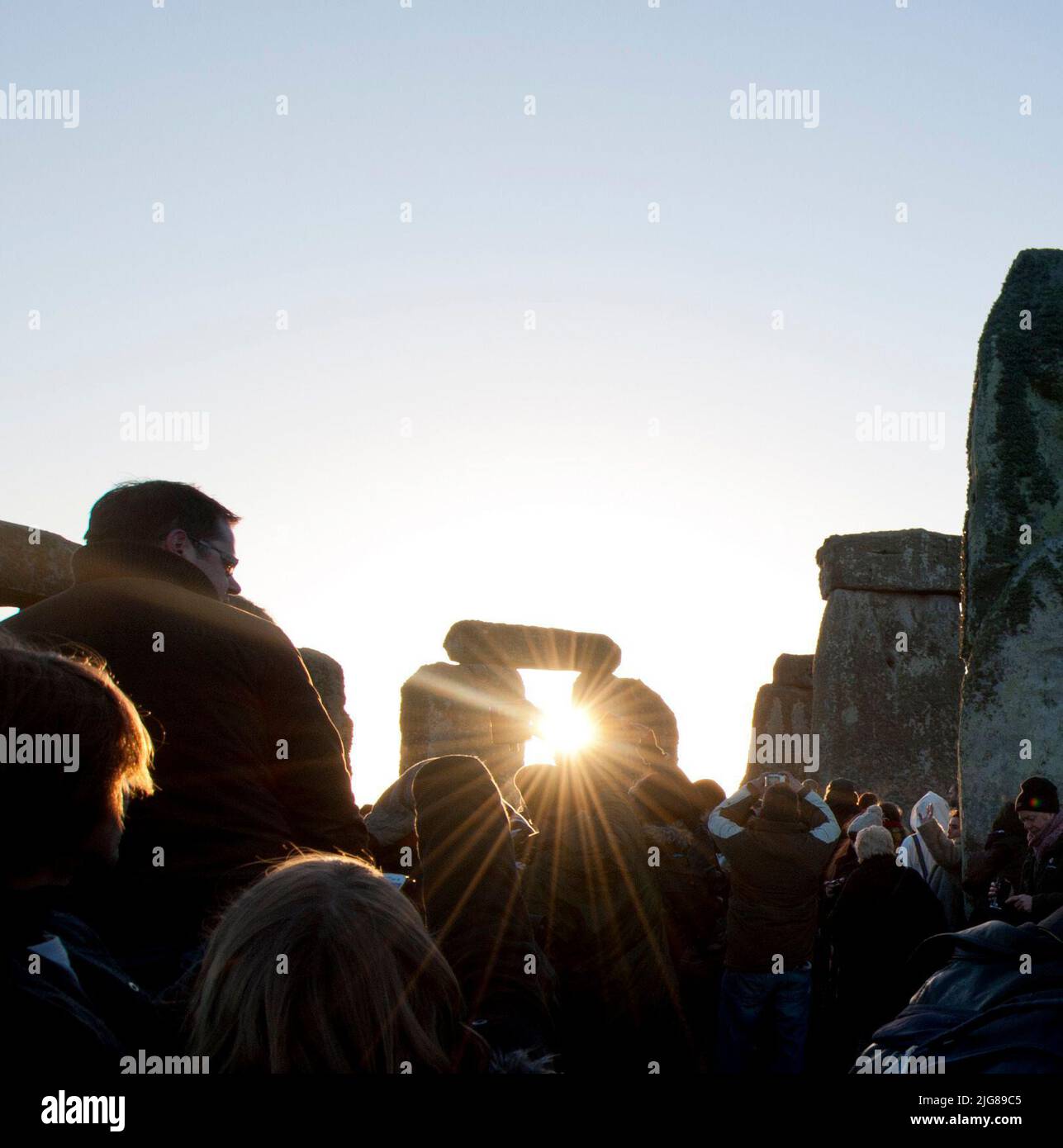 Stonehenge, Stonehenge Down, Amesbury, Wiltshire, 19-12-2012. General view of crowds watching the sun rise through a trilithon at Stonehenge on the winter solstice. Stock Photo