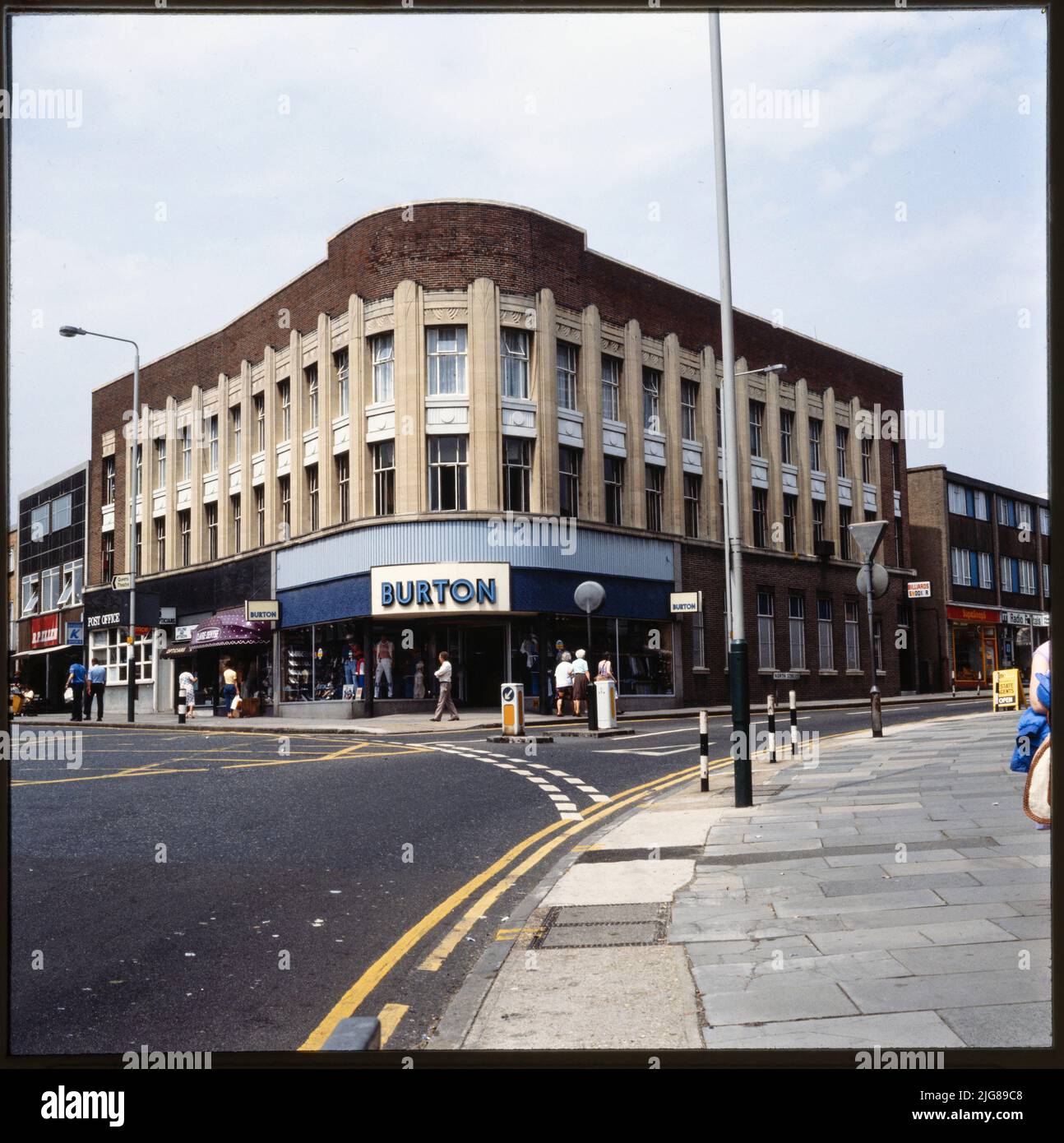 Burton, 127-133 High Street, Hornchurch, Havering, Greater London Authority, 1970s-1990s. The curved elevation of the Burton store on the corner of High Street and North Street, with the adjoining shops on either side. Foundation stones were laid at the site by members of the Burton family in 1939. The shop units in the building were occupied by businesses including the Post Office, Dollond and Aitchison Opticians, Dorothy Perkins, Douglas Estate Agents, and Boots. Stock Photo