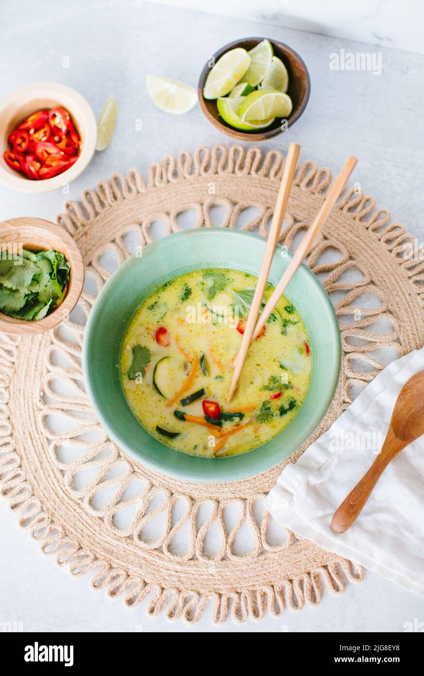 A top view of Thai coconut soup with garnishes Stock Photo