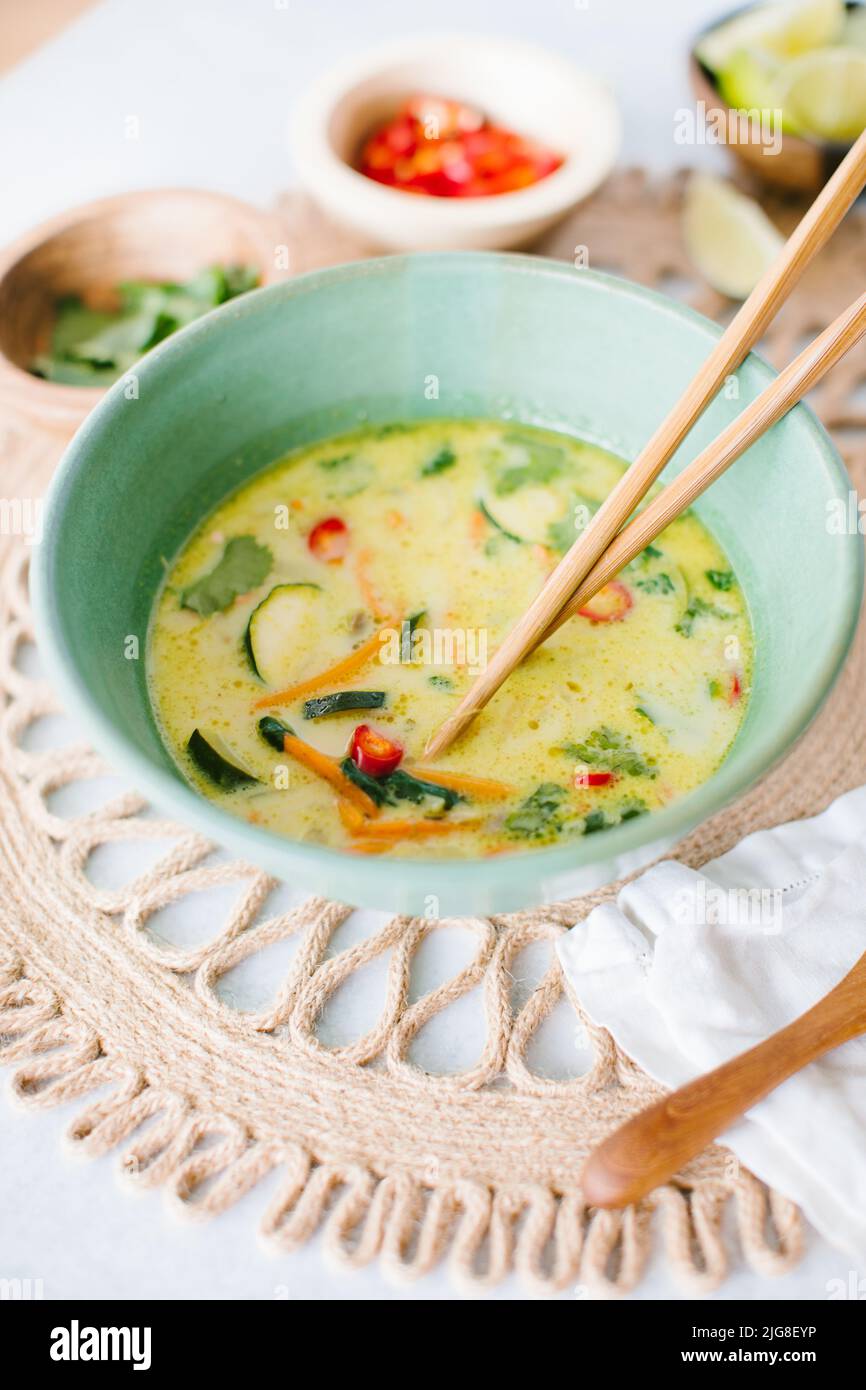 A closeup of Thai coconut soup with garnishes Stock Photo
