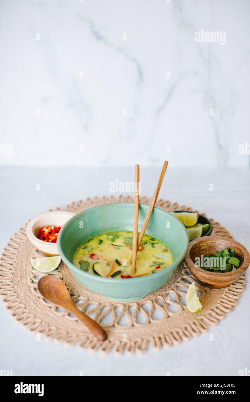 A vertical shot of Thai coconut soup with garnishes Stock Photo
