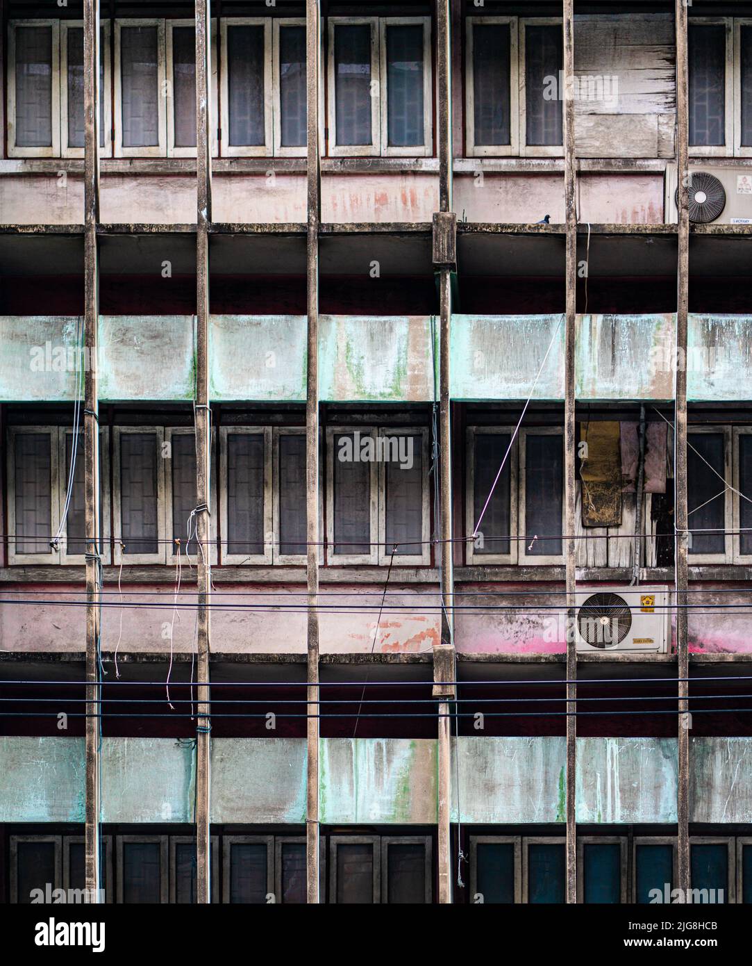 Old weathered facade wirh aicon compressors ,Bangkok. Vertical shot Stock Photo