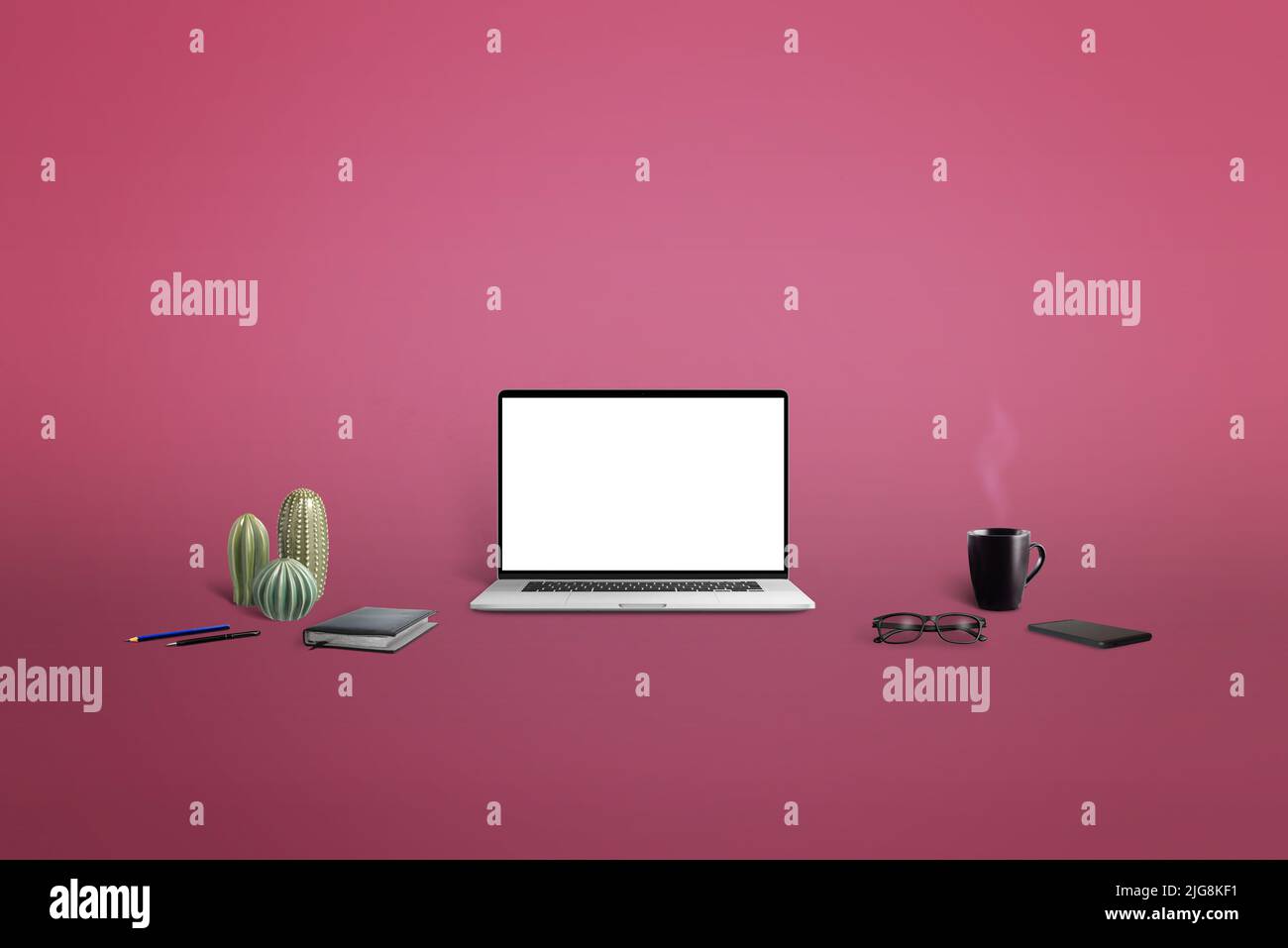 Laptop mockup surrounded by things to work on rose background. Isolated screen for web page presentation Stock Photo