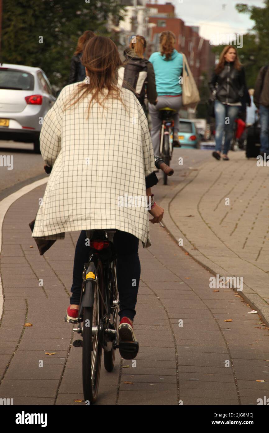 A rear view of a woman riding a bicycle in the city Stock Photo - Alamy