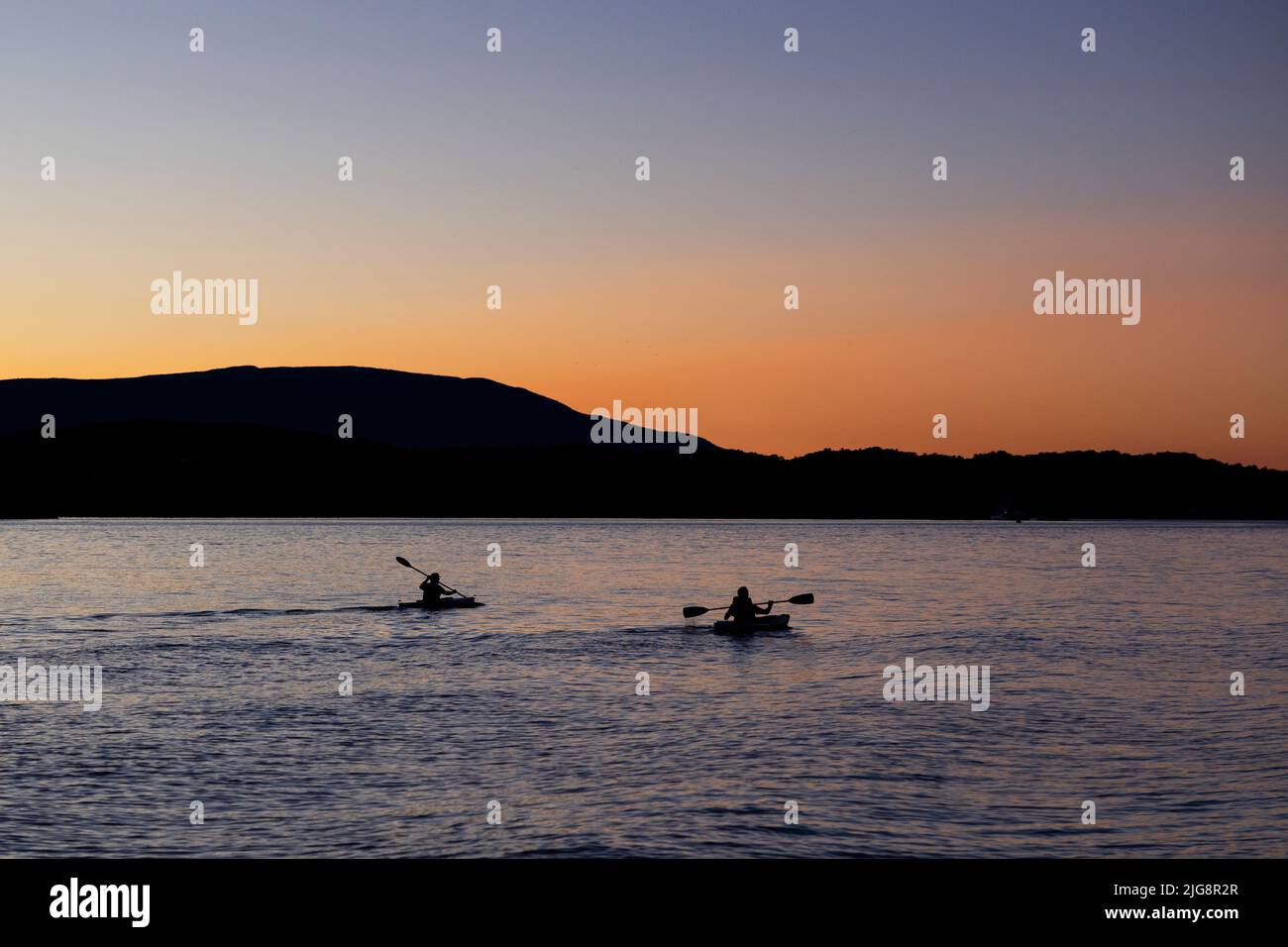 Two kayakers on the Hudson River at sunset in Tivoli, New York, USA. Stock Photo