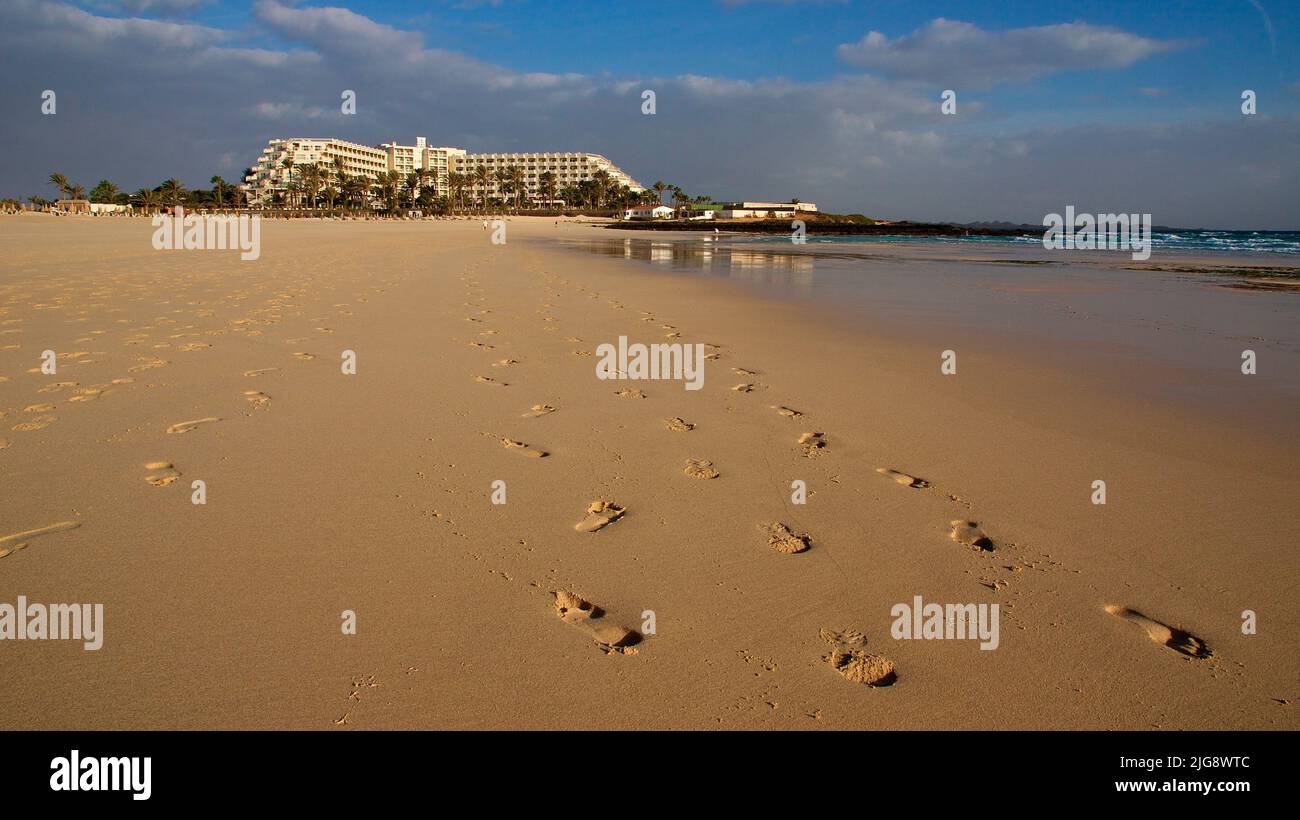 Spain, Canary Islands, Fuerteventura, Corralejo, wide angle shot, sandy beach, footprints, hotel complex, sky blue with clouds Stock Photo