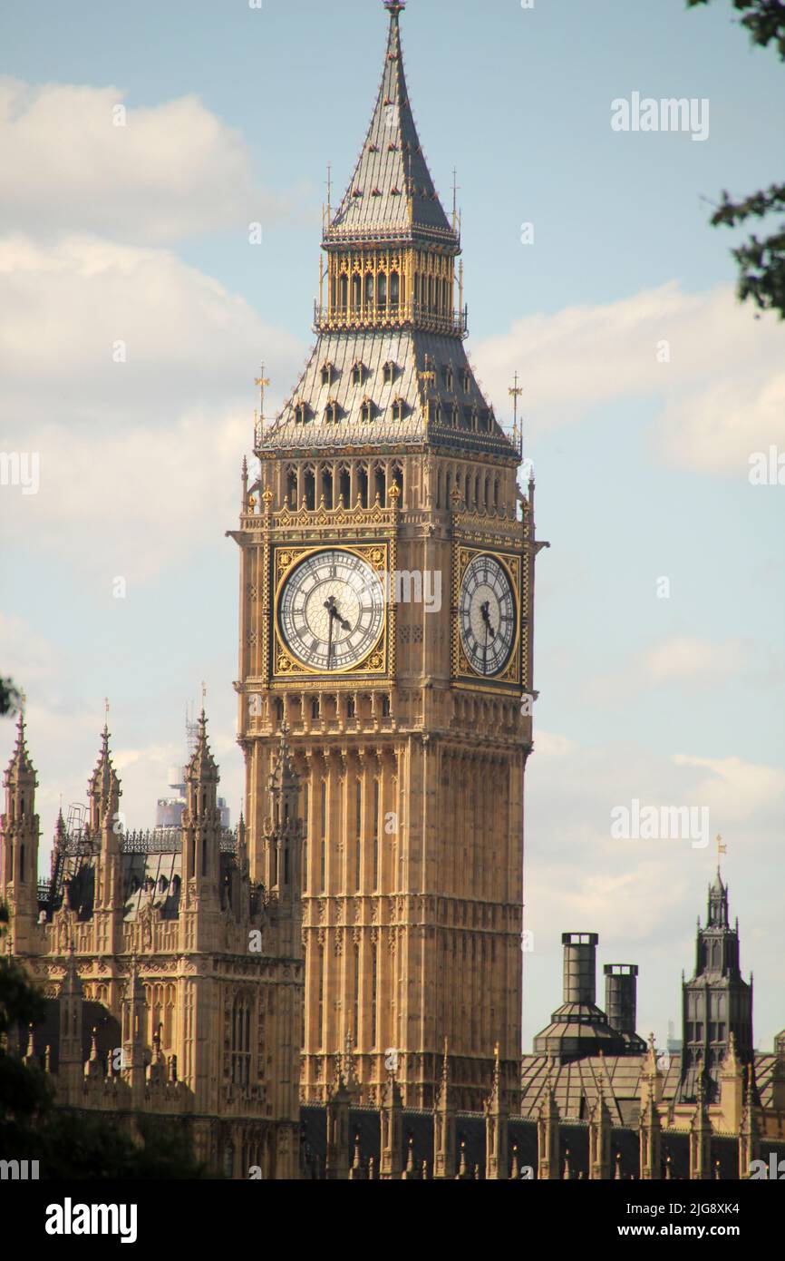 A vertical shot of the historical Big Ben against a blue cloudy sky in London, United Kingdom Stock Photo