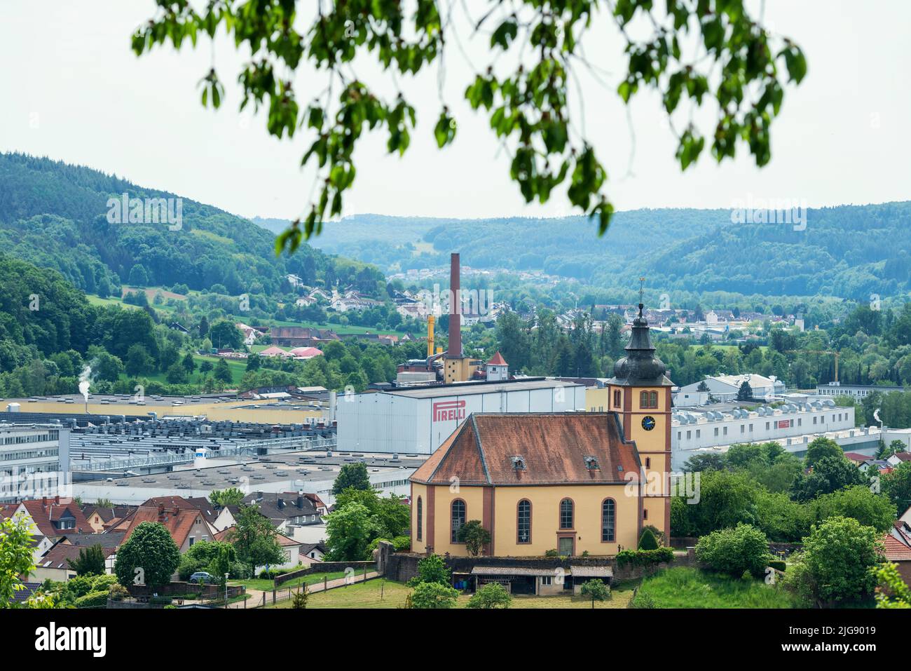 Breuberg, Hesse, Germany, view of the Lutheran parish church in the Sandbach district of Breuberg. In the background the Pirelli factory. Stock Photo