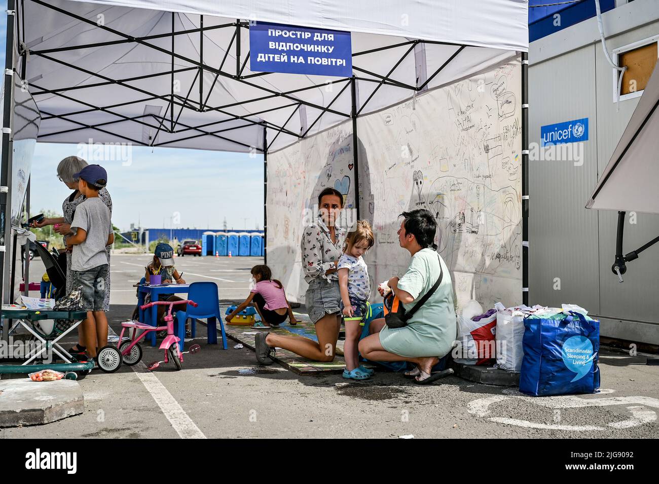 ZAPORIZHZHIA, UKRAINE - JULY 8, 2022 - Women and children stay at an outdoor space on the premises of the upgraded largest hub for internally displace Stock Photo
