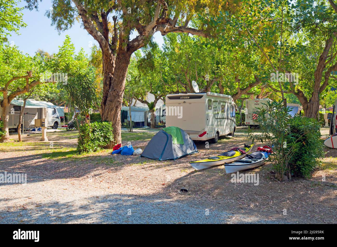 Campers, tent with kayaks under trees on a campsite on the island of Elba Stock Photo