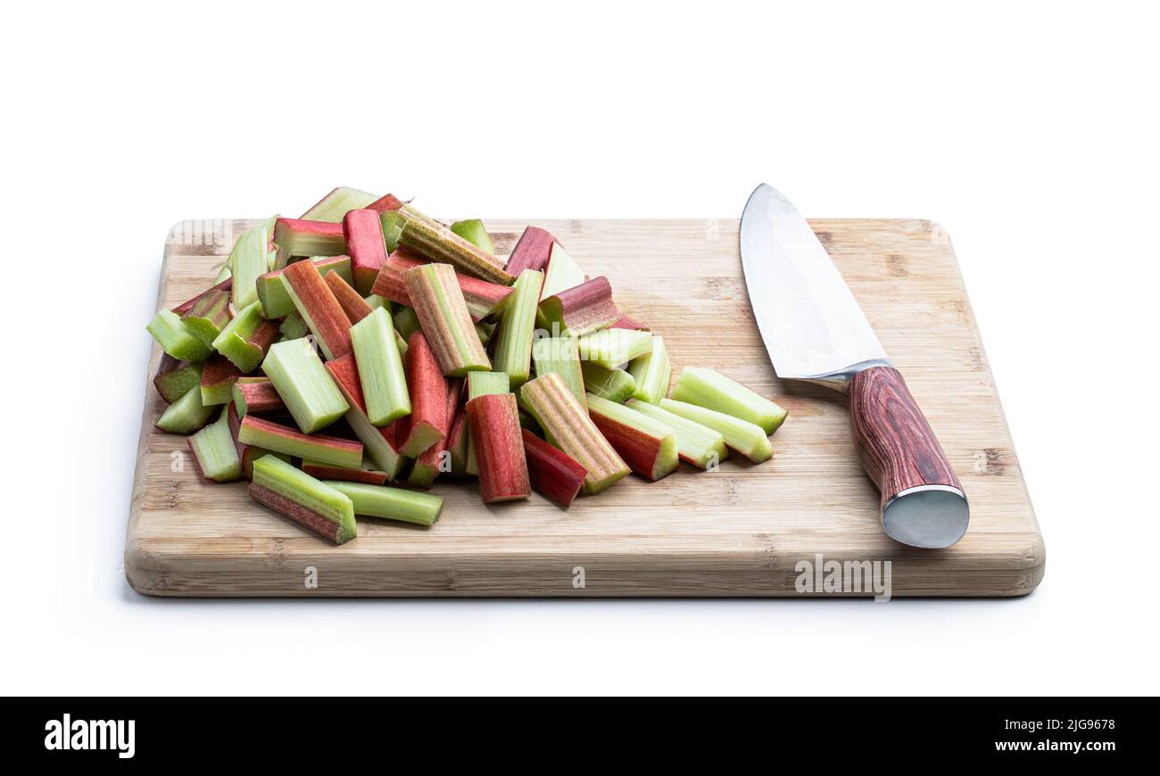 Chopped  rhubarb stalks on wooden board isolated on white Stock Photo