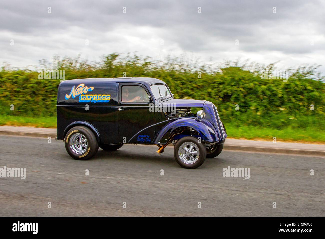 117 Fordson 8 Van (Mod Hot Rod) Van. 1948 40s blue purple forties Ford Anglia 'Nitro Express' based on Fords 5cwt Van. Hot rods cars, drag cars, ANGLIA, hot rod, retro, drag racing, race gasser, street rods. Modified cars en-route to Hoghton Tower for the Supercar Summer Showtime car meet which is organised by Great British Motor Shows in Preston, UK Stock Photo
