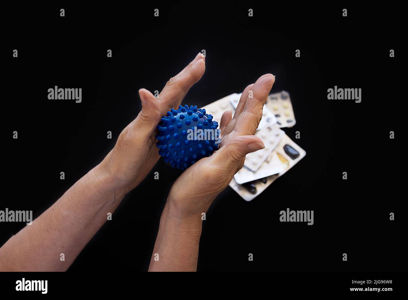 female hands squeeze ball for selfmassage from arthritis, on a black