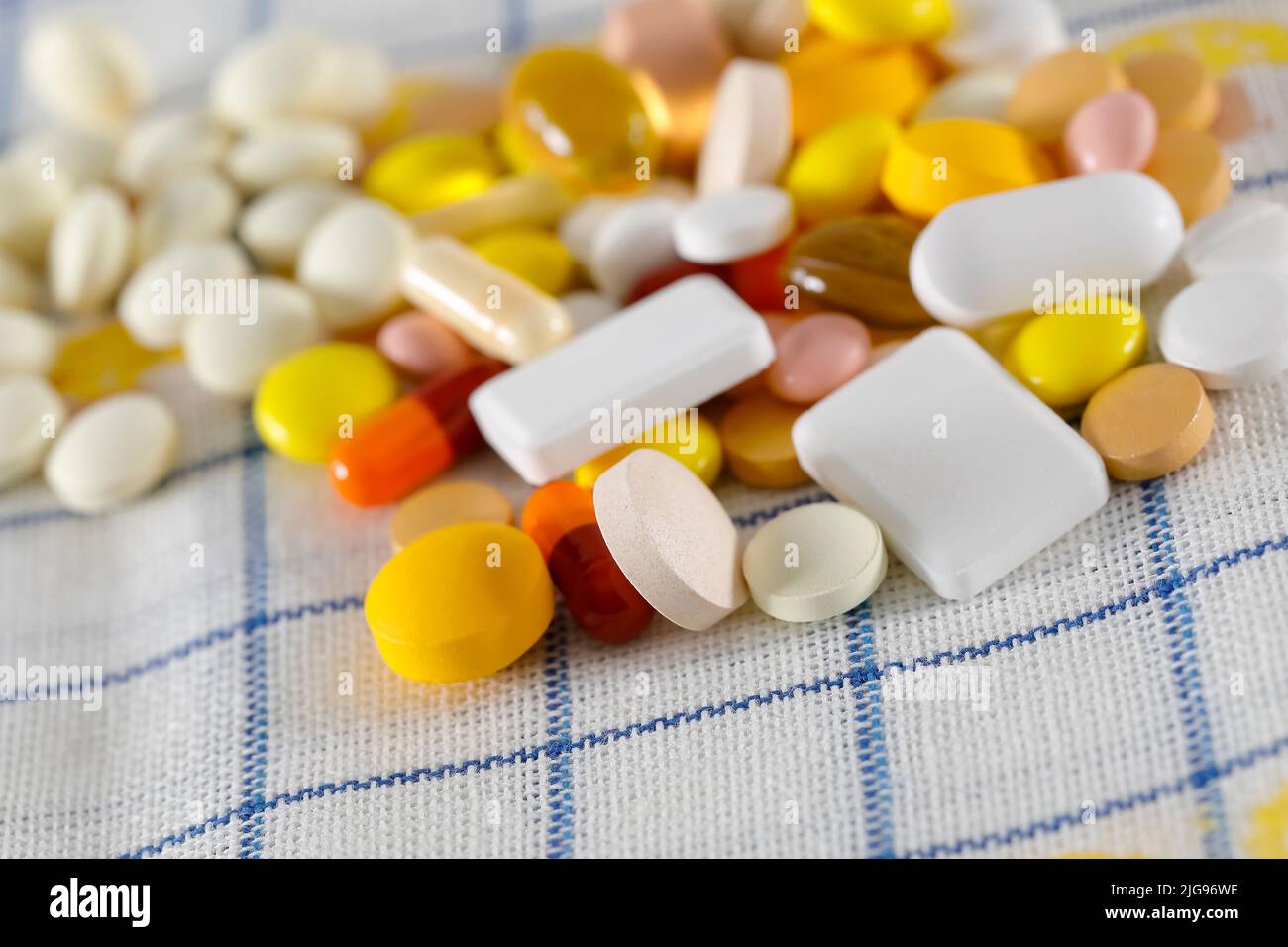 The pills are on the napkin. These varied tablets have various shapes and various colors. Stock Photo