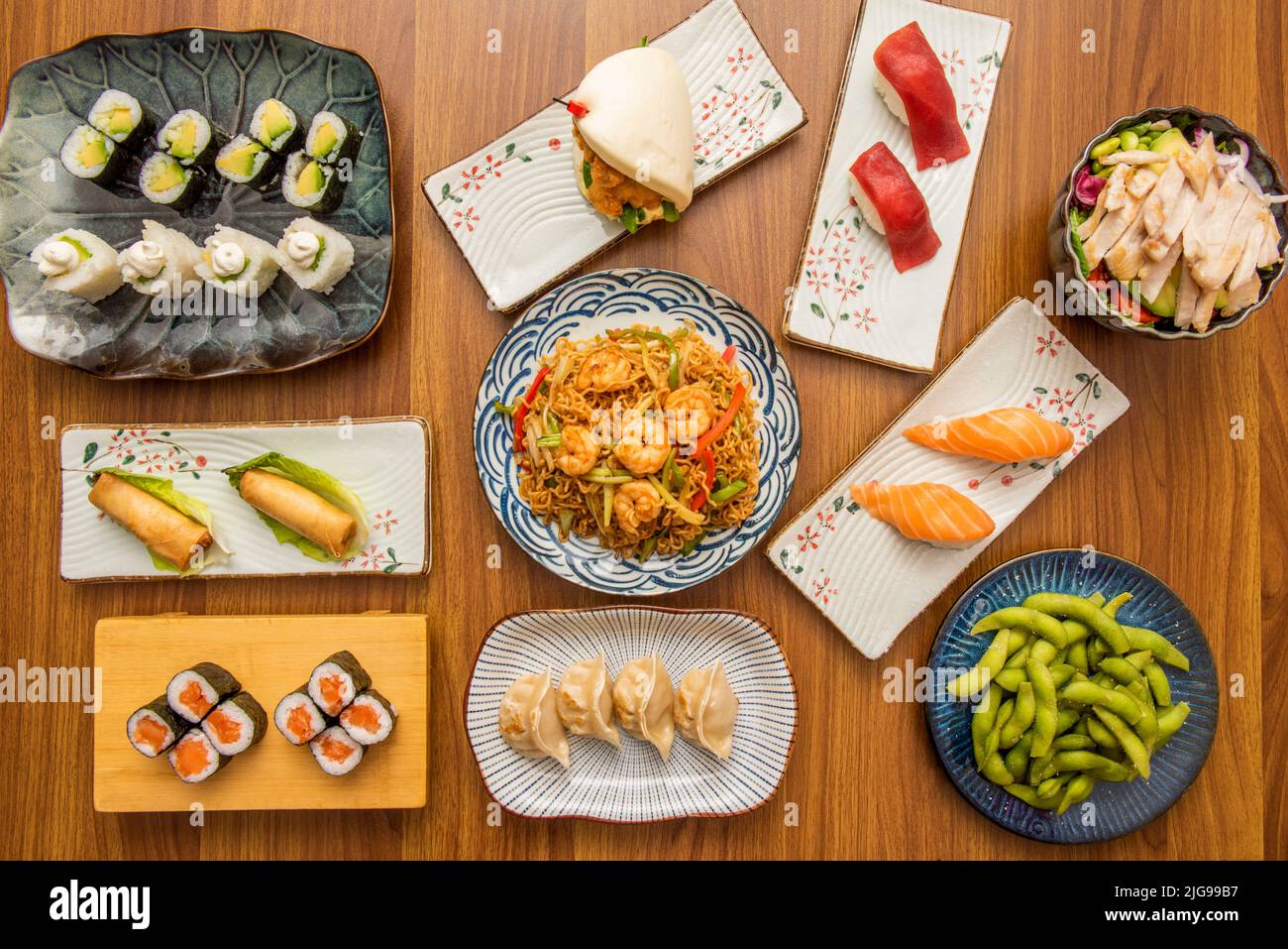 set of asian food dishes with sushi, avocado maki, shrimp noodles ...