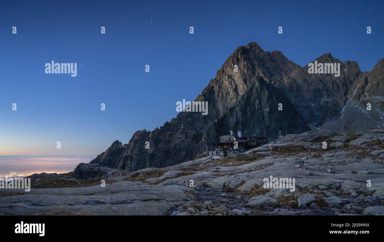 Peaceful alpine scenery with mountain and hut beneath it just before sunrise, Slovakia, Europe Stock Photo