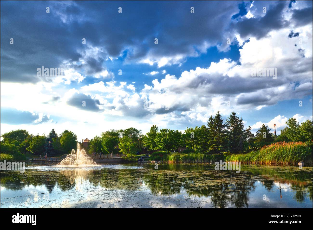 Sunset landscape of a public park with pond and fountain in Toronto, Ontario, Canada. Stock Photo
