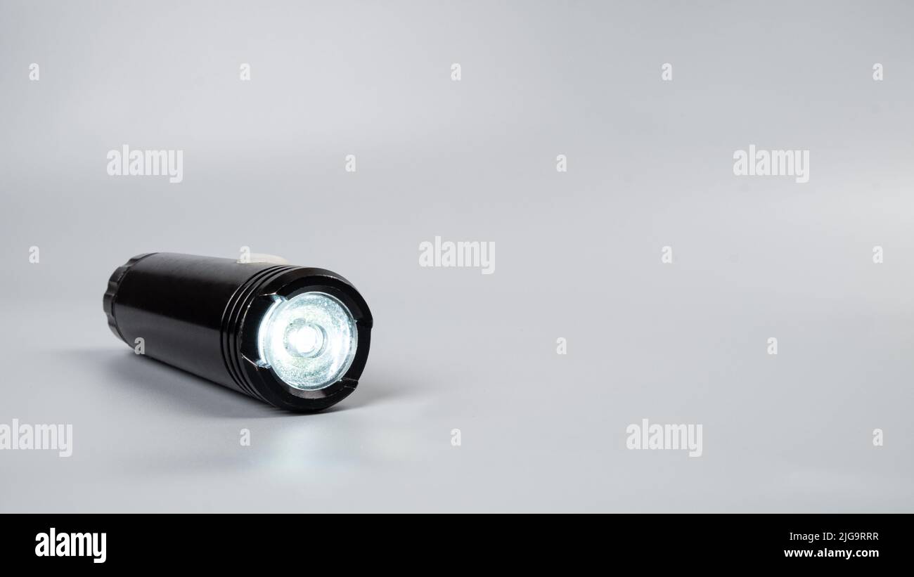 led flashlight on gray background with copy space. Stock Photo