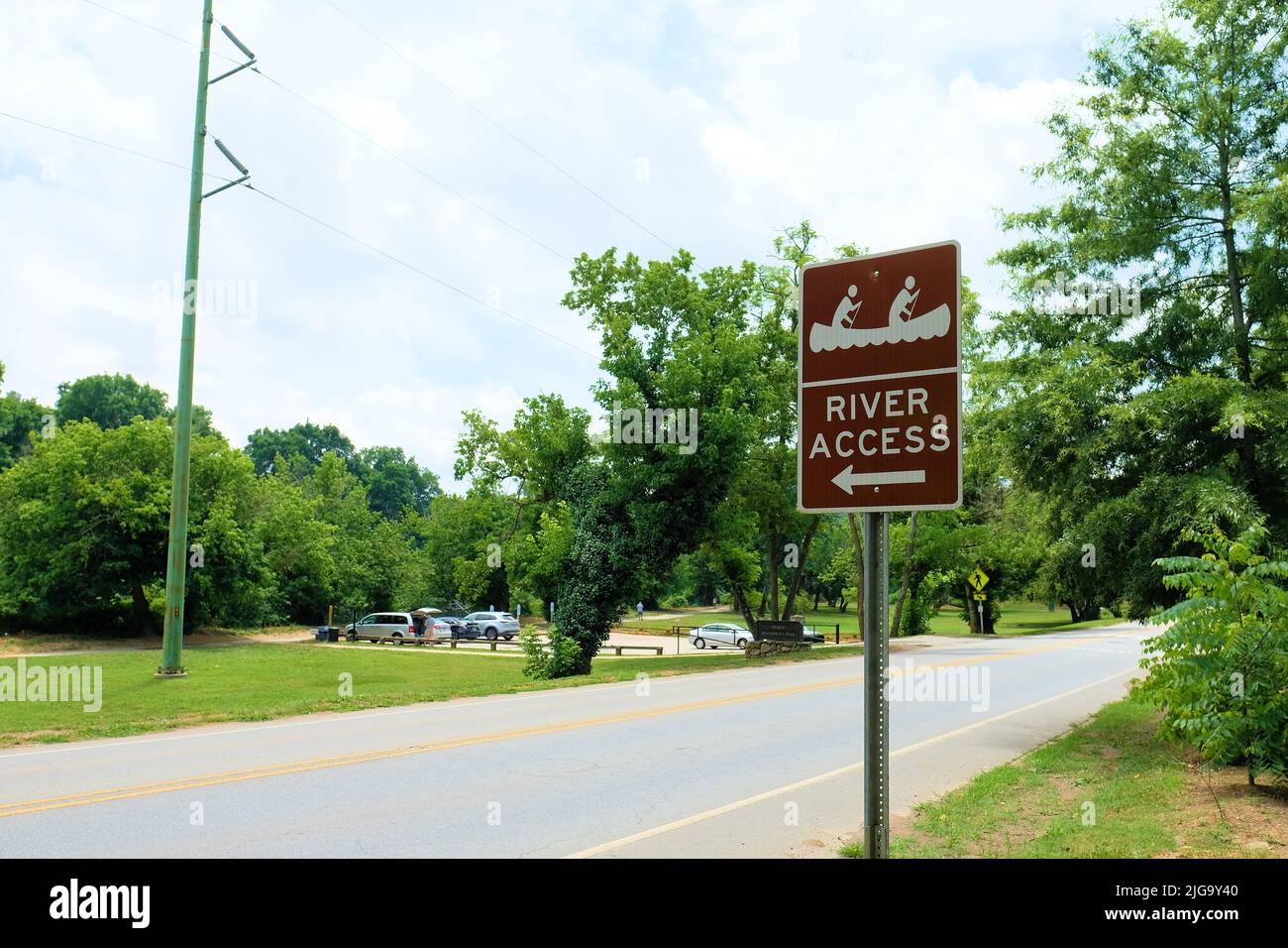 Roadside River Access sign with canoe icon pointing to a French Broad River recreational area; Amboy Riverfront Park; Asheville, North Carolina Stock Photo