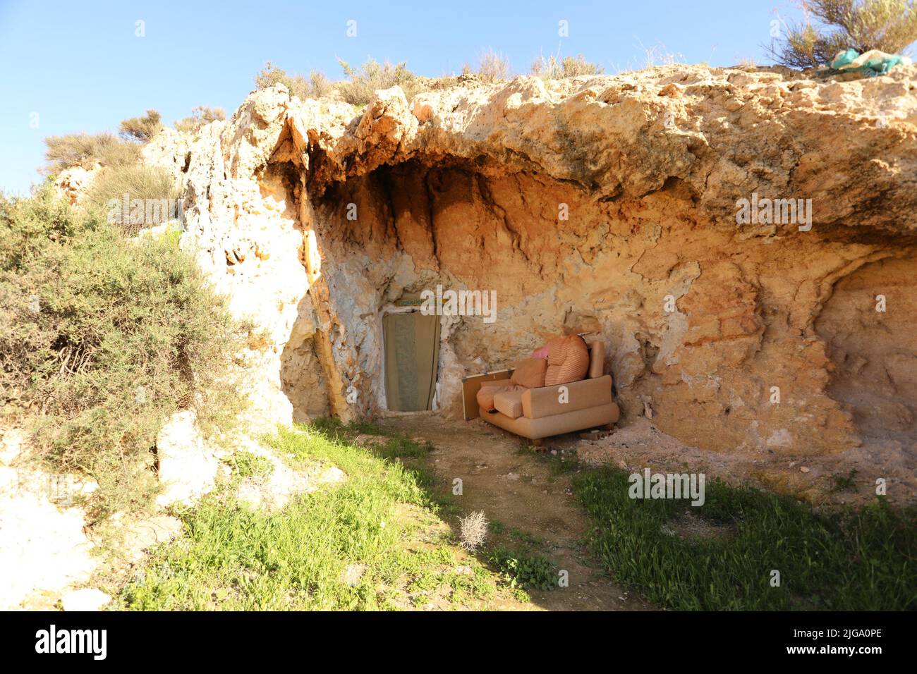 Door entrance of the natural caves in the cliff big rock in Almeria Stock Photo