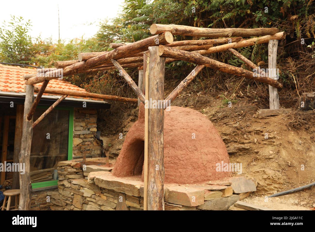 Pizza oven homemade in the garden with a wooden roof. Open fire pizza oven Stock Photo