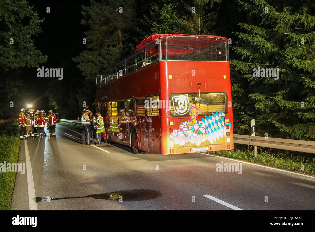 Steinberg Am See, Germany. 09th July, 2022. Rescue workers stand next to a double-decker bus. A celebration on the deck of an open-top party bus ended with serious injuries for a 27-year-old man on Friday evening. The party guest got up from his seat during the ride on the double-decker bus and crashed into the low highway bridge near an underpass in Steinberg am See (Schwandorf district), according to police. Credit: Bauernfeind/vifogra/dpa/Alamy Live News Stock Photo